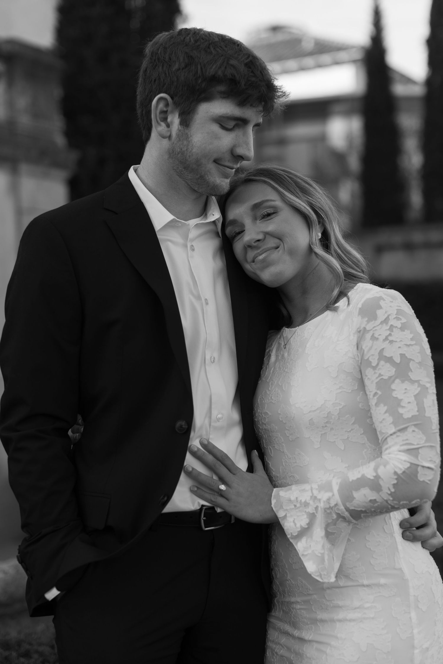 Black and white romantic portraits captured in sequence against architectural backdrop.