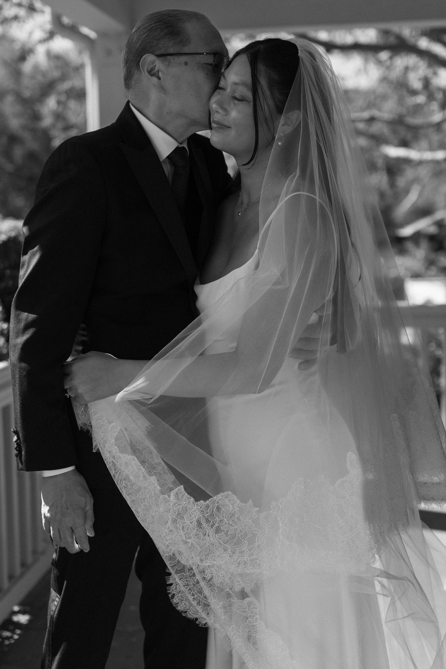 Black and white wedding photos showing tender moments under a covered porch.