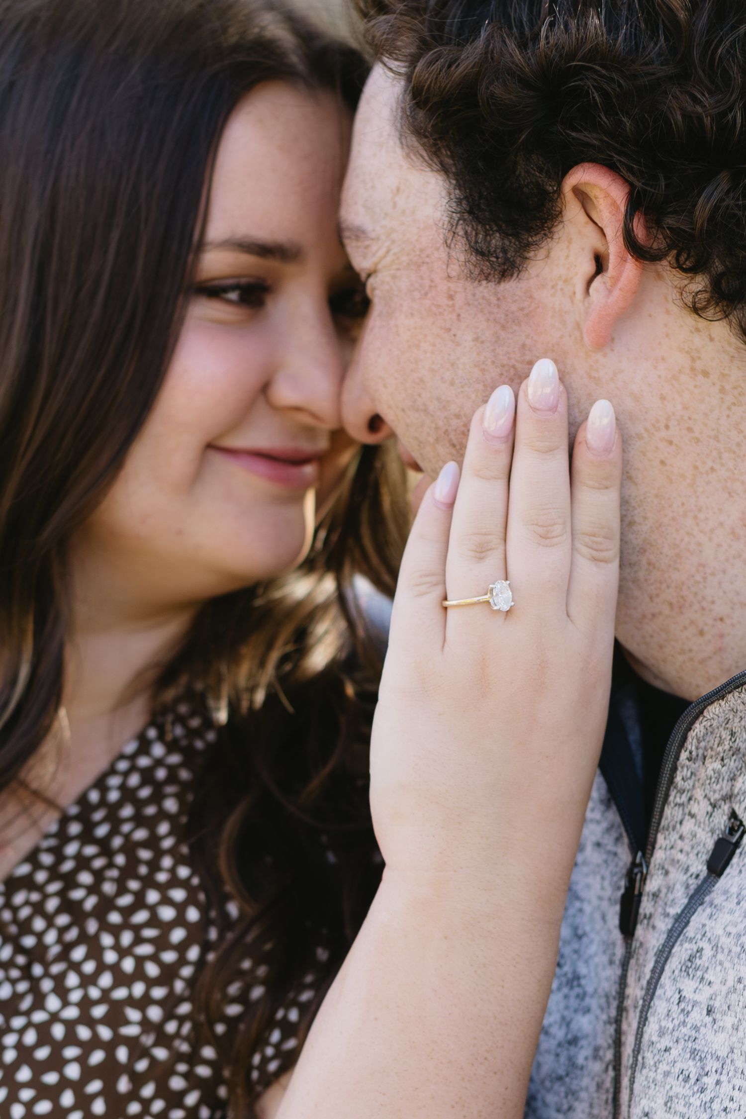 A close-up shot showing an engagement ring as a couple shares an intimate moment.