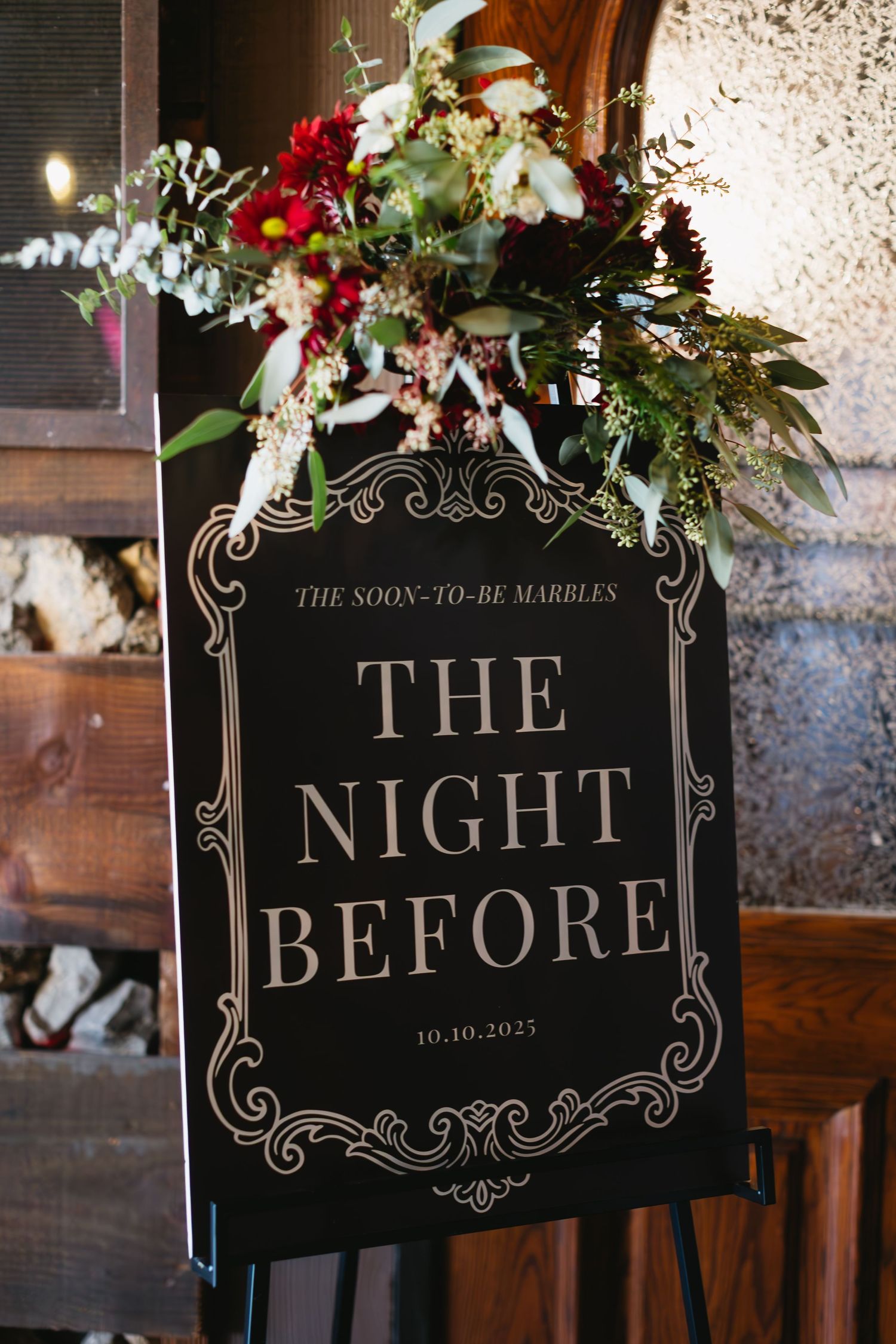 Elegant black wedding signs with ornate text and floral decorations reading 'The Night Before'.