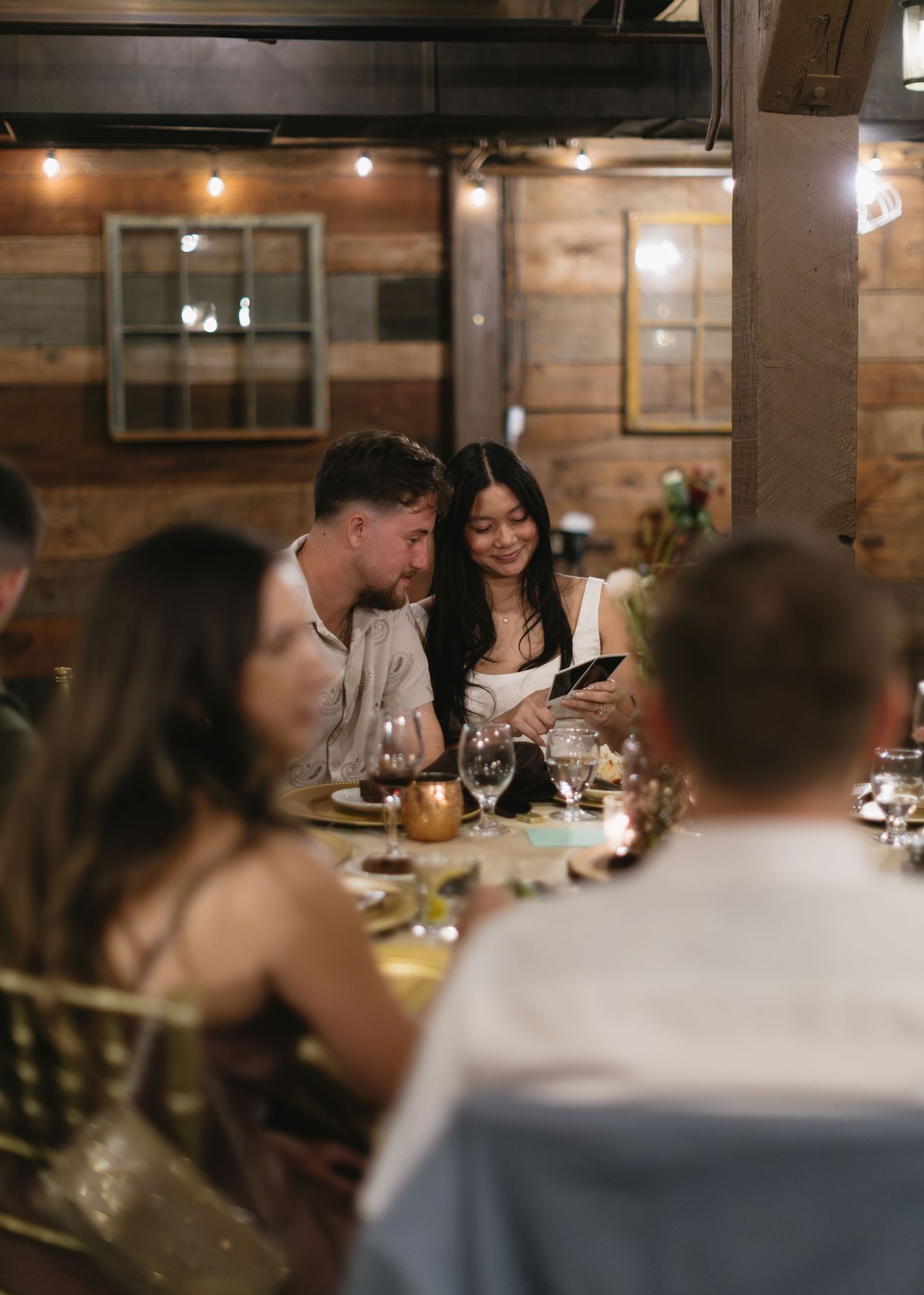 Guests enjoying a celebratory dinner in a rustic restaurant setting.