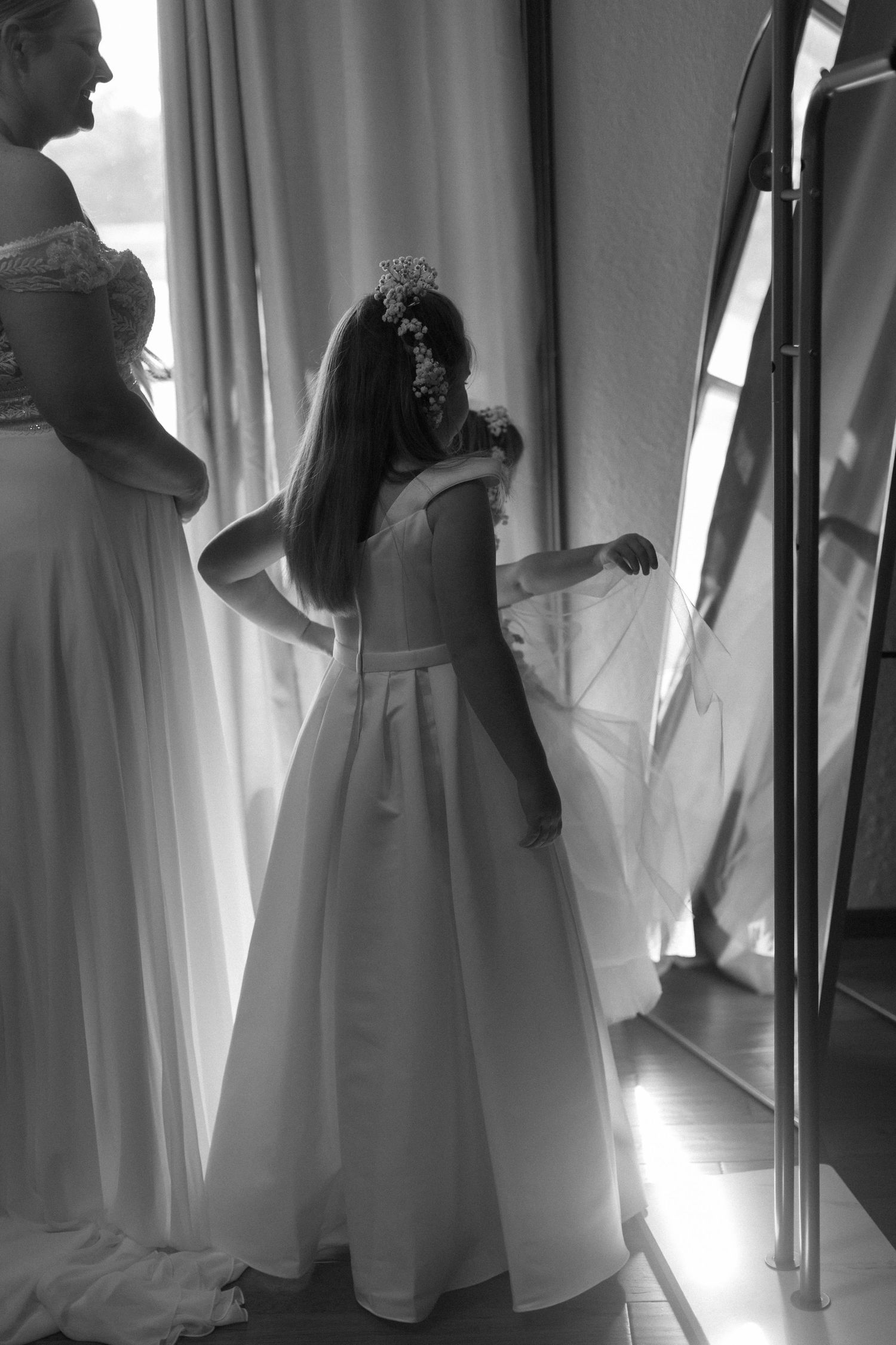 Artistic sequence showing a wedding dress in silhouette against window light.