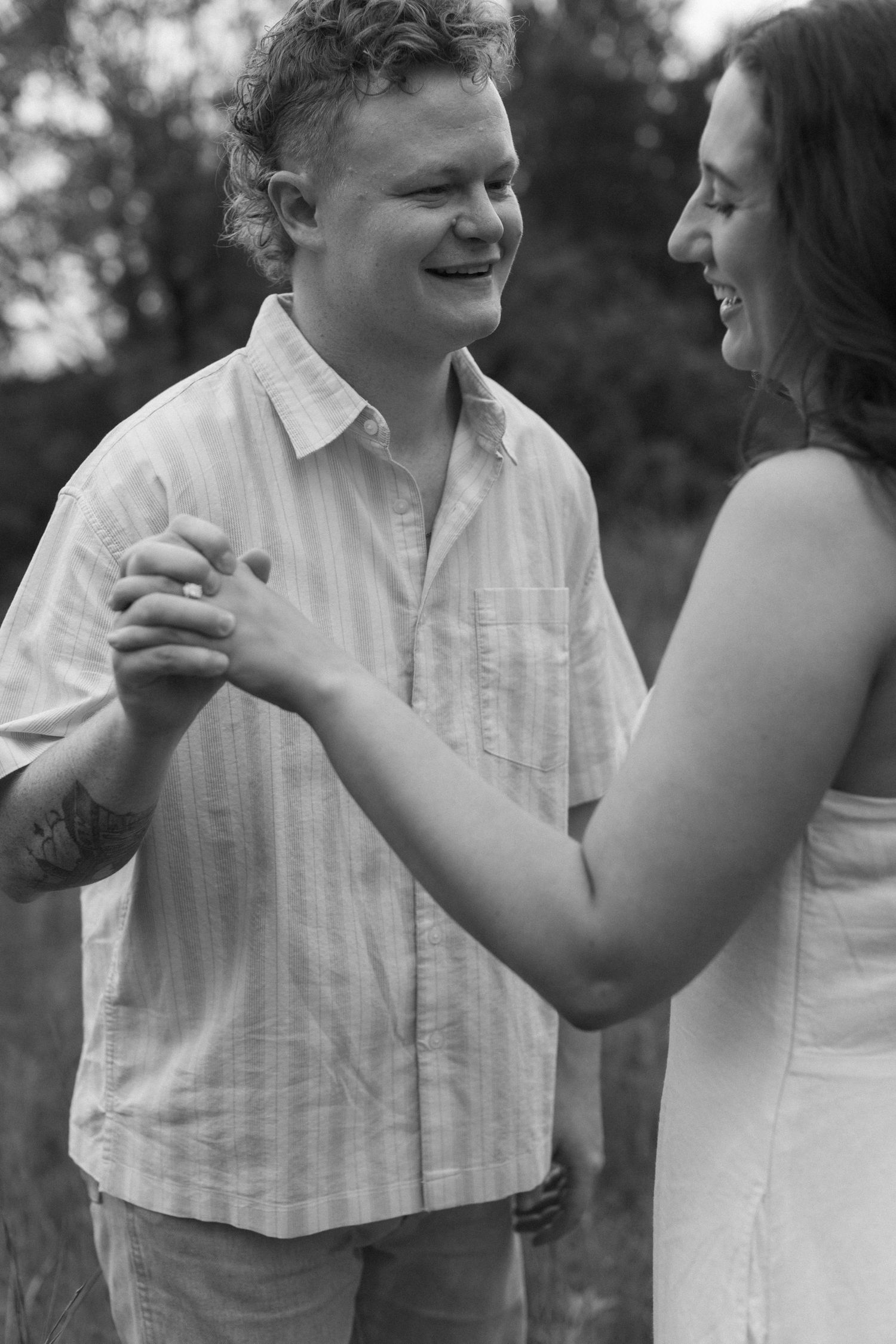 Candid black and white photos capturing sweet moments between a couple in matching white outfits.