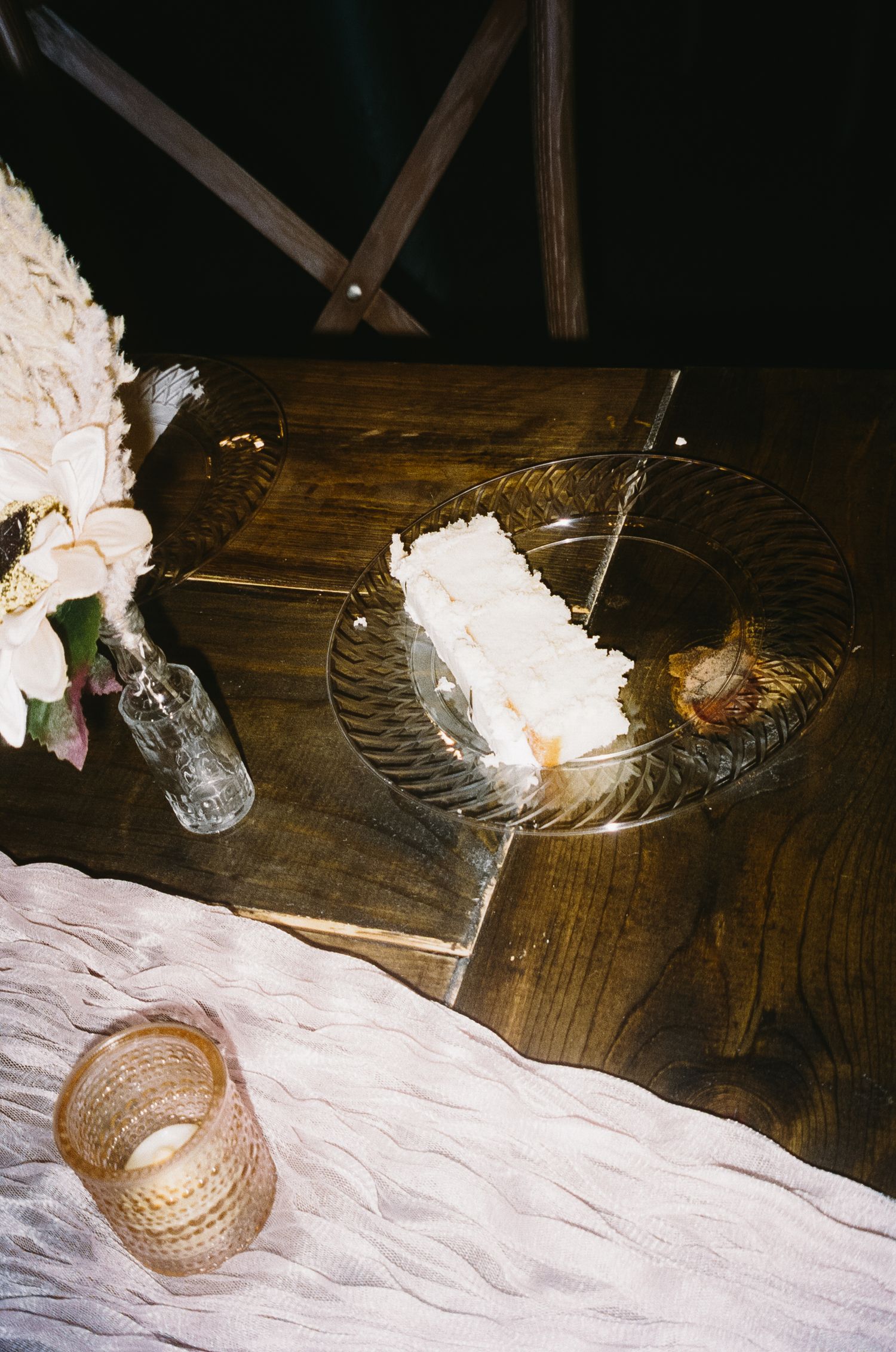 Decorative table setting with white floral arrangements and gold accents on dark wooden surfaces.