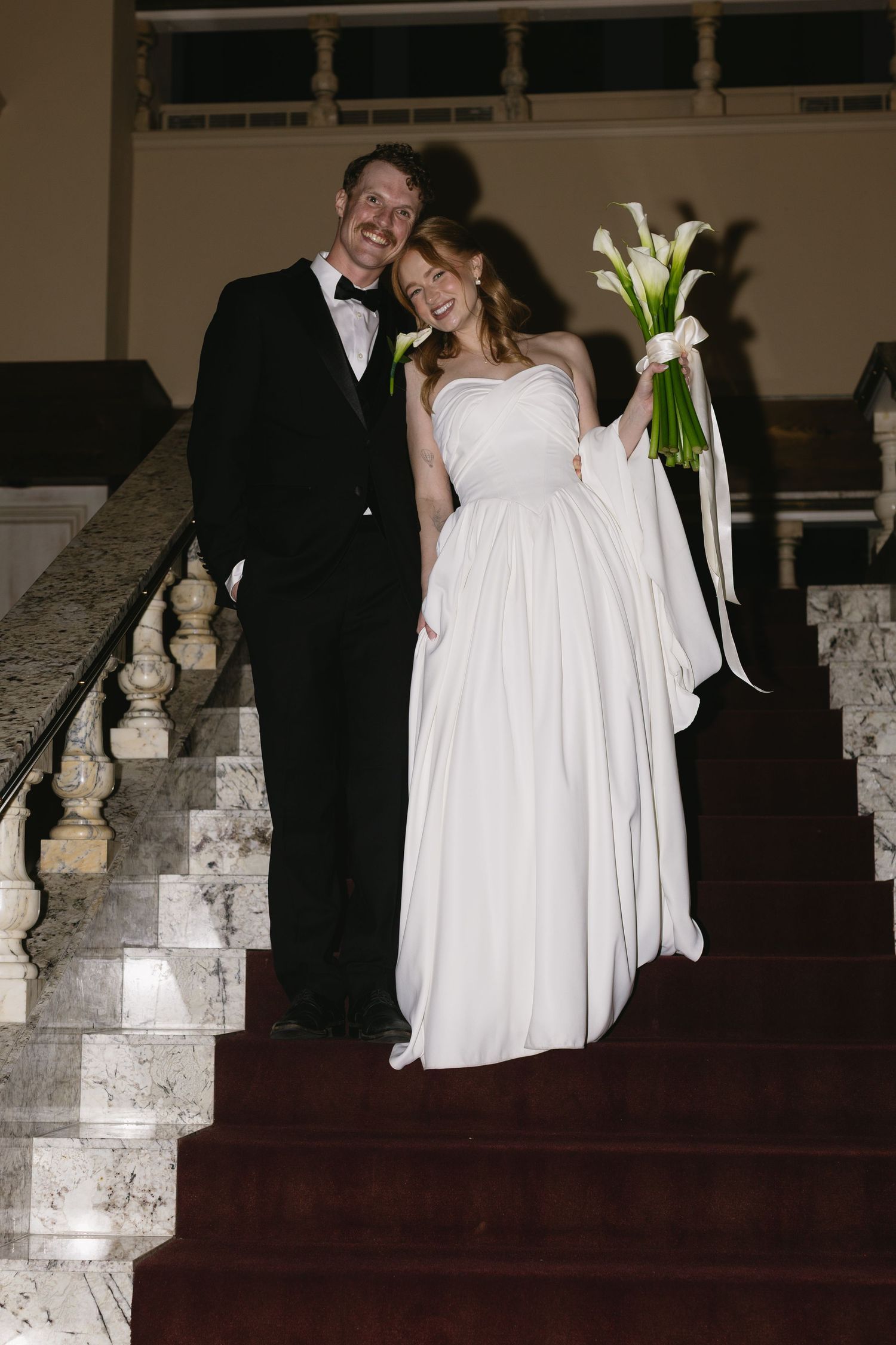 Romantic wedding portraits on stone steps with calla lily bouquet at dusk.