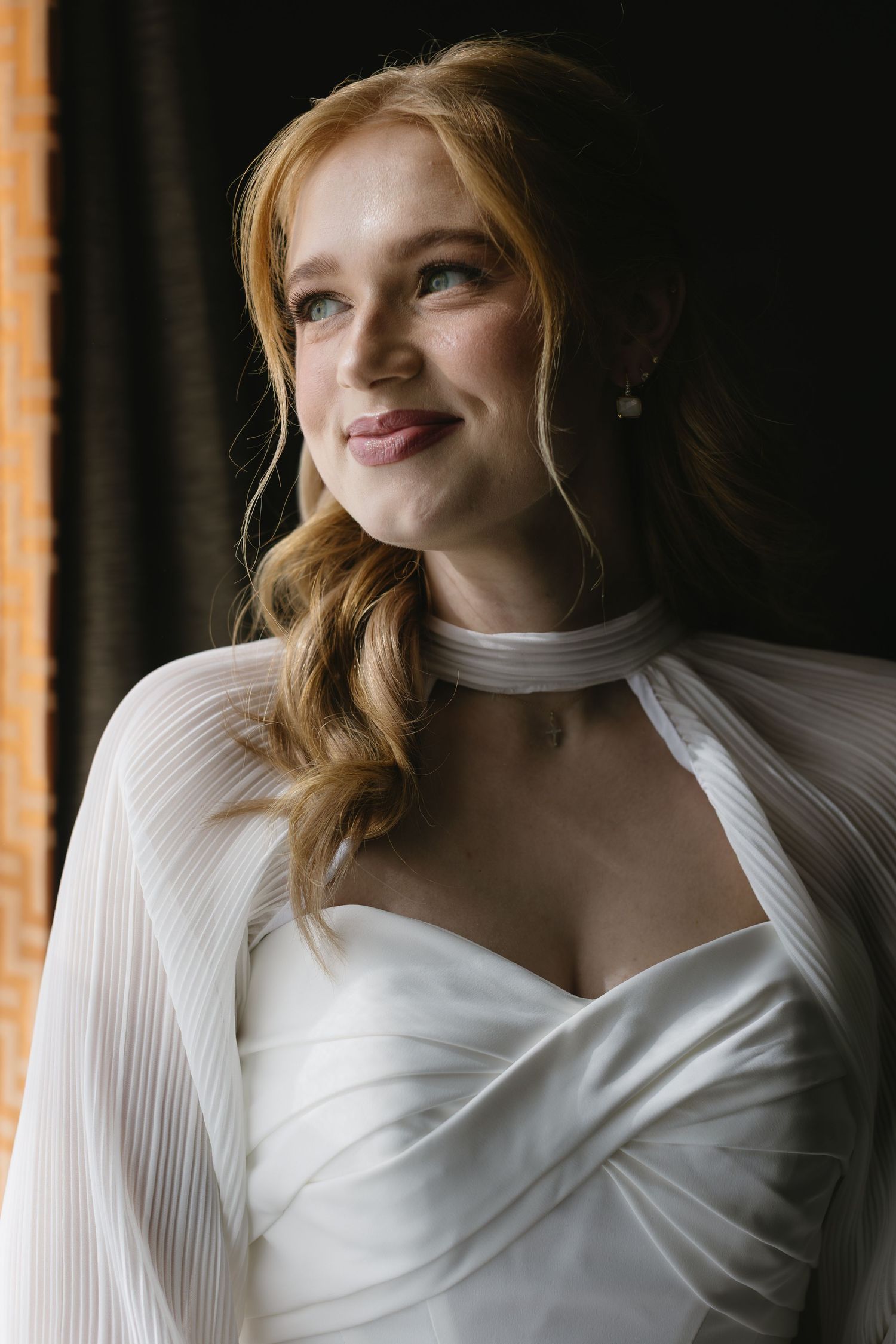 Elegant white bridal gown with pleated details captured in natural light.