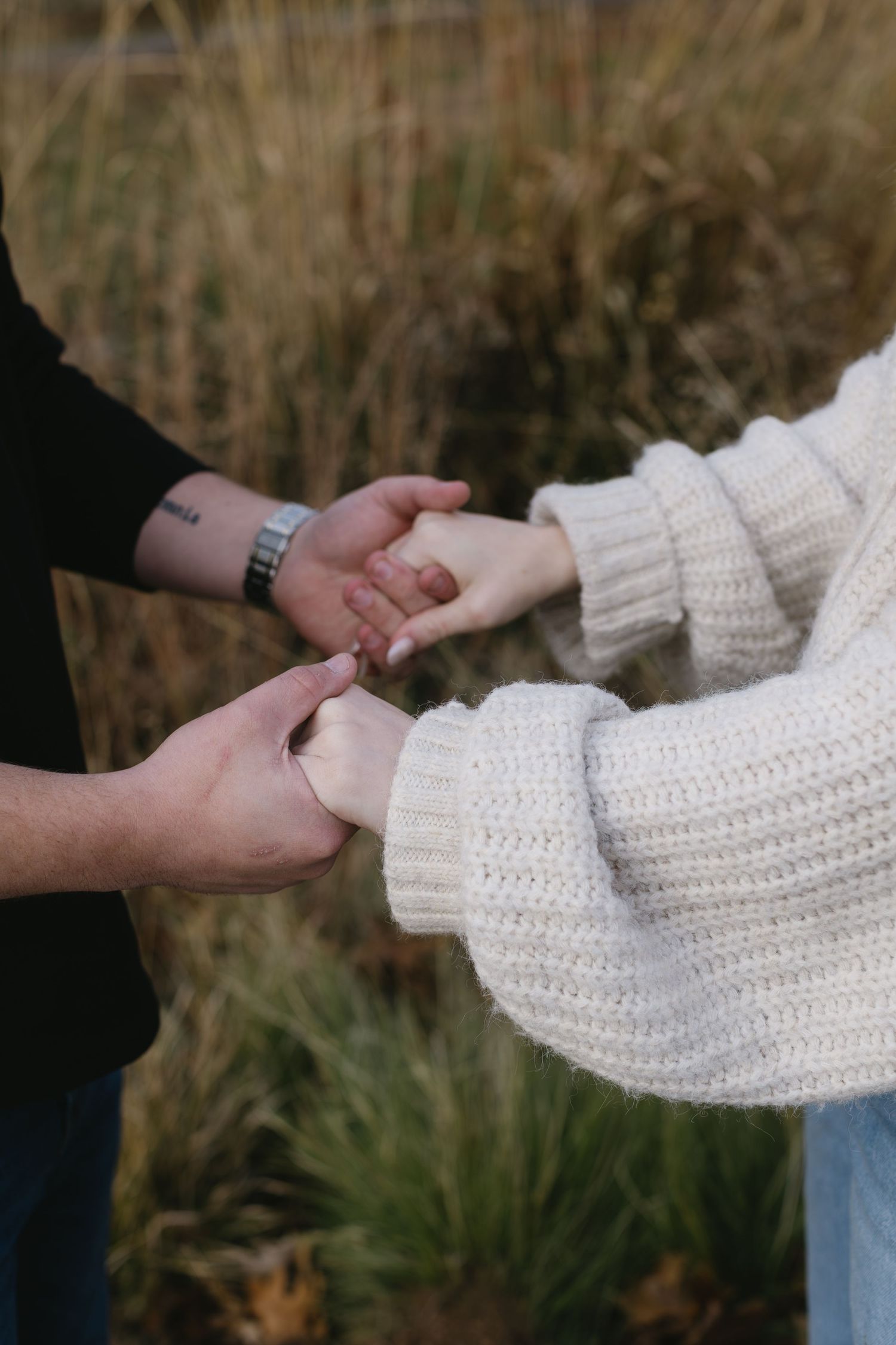 Close-up shots of hands holding each other against a natural outdoor background.