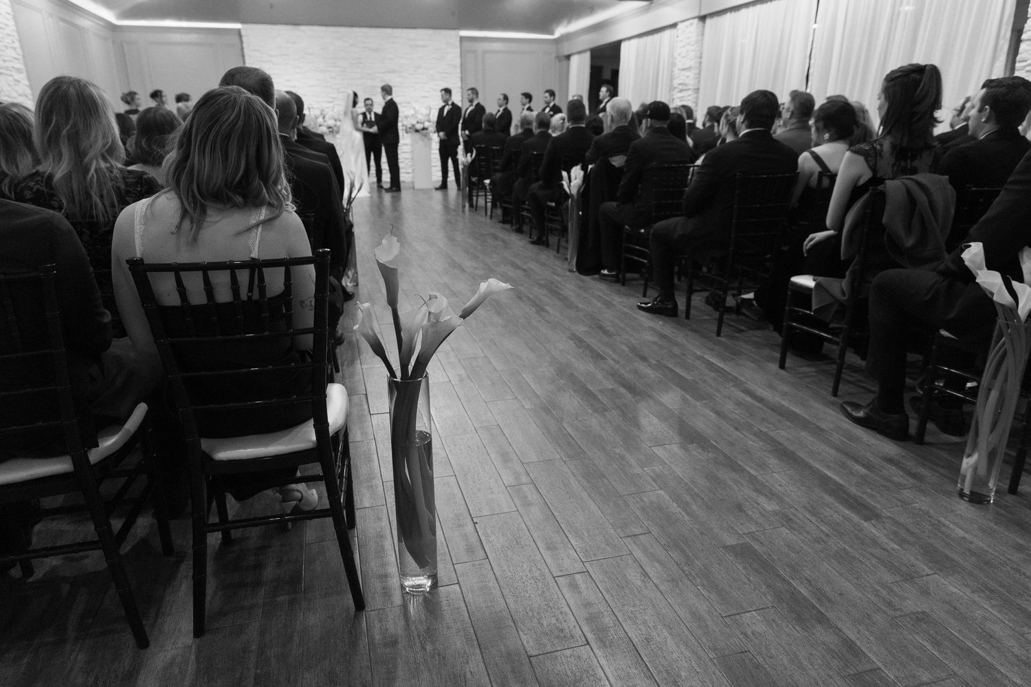 Panoramic view of wedding ceremony space with wooden floors and rows of chairs.