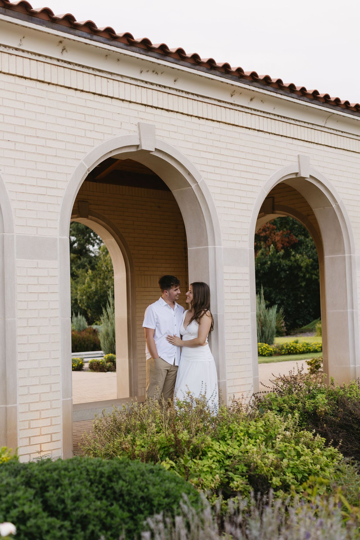 White arched colonnade provides an elegant backdrop for a romantic photoshoot.