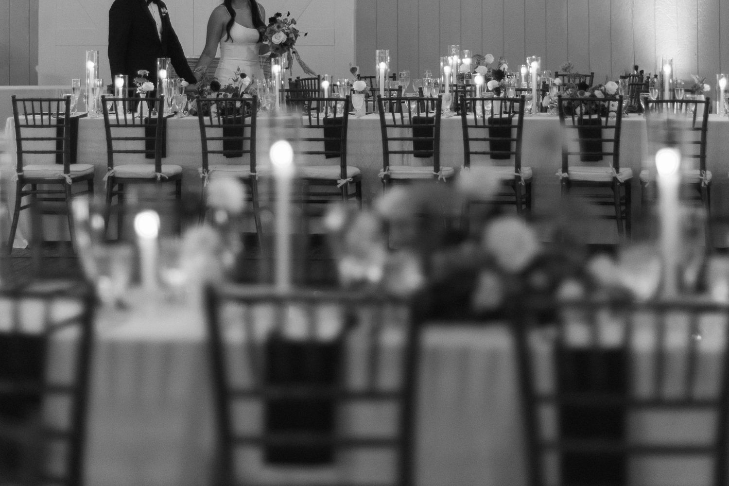 Reception venue with elegant table settings and chairs arranged in rows.