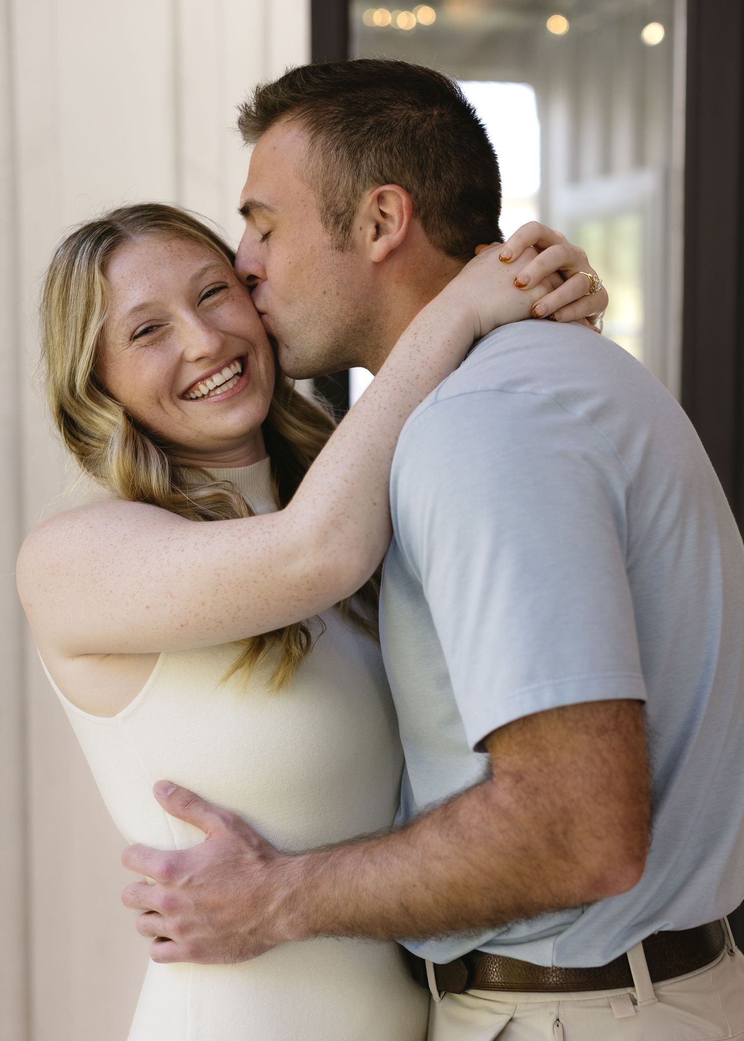 A couple shares an intimate embrace and tender kisses in a series of romantic candid photos.
