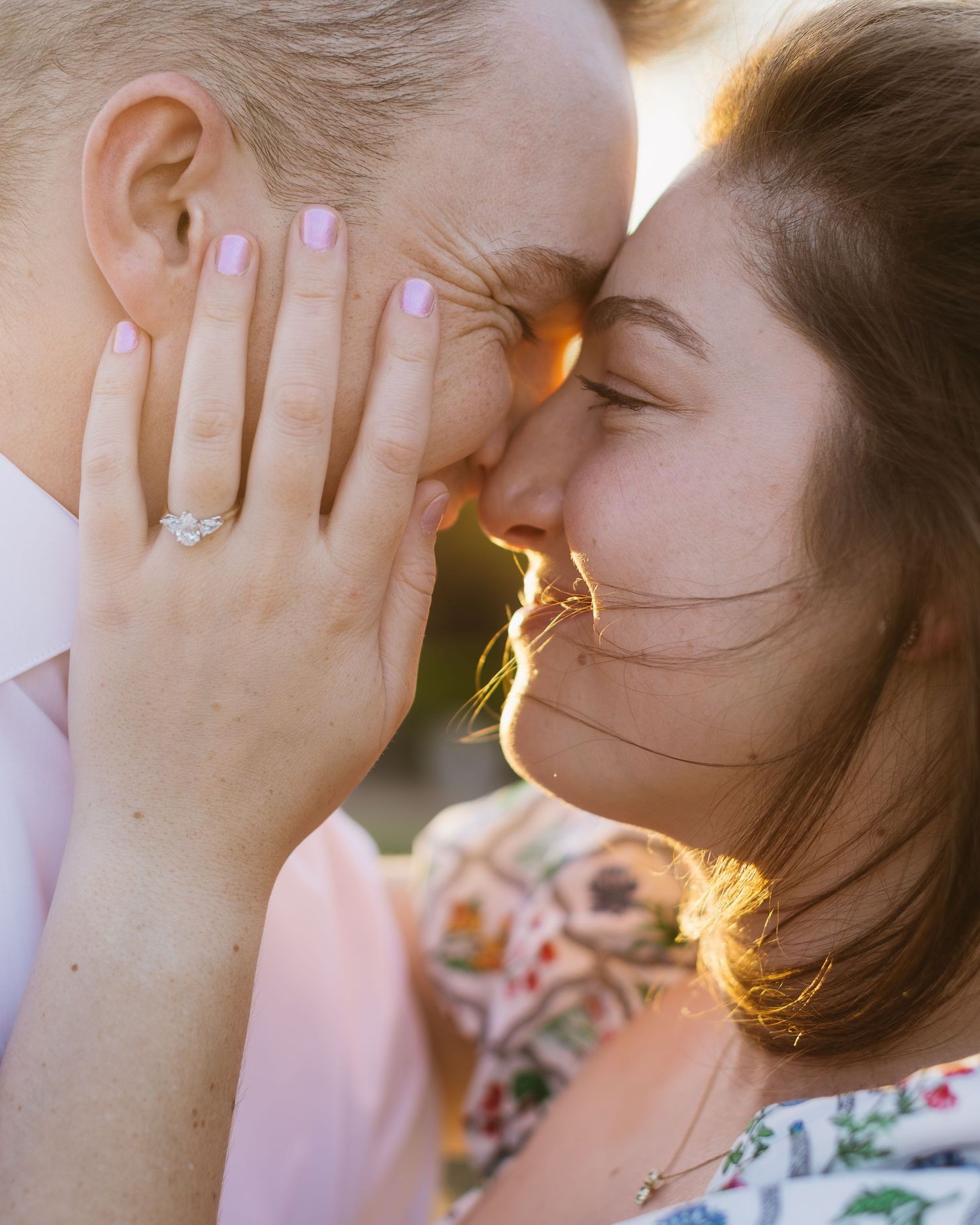 Romantic sunset portraits showing hands displaying an engagement ring against golden light.