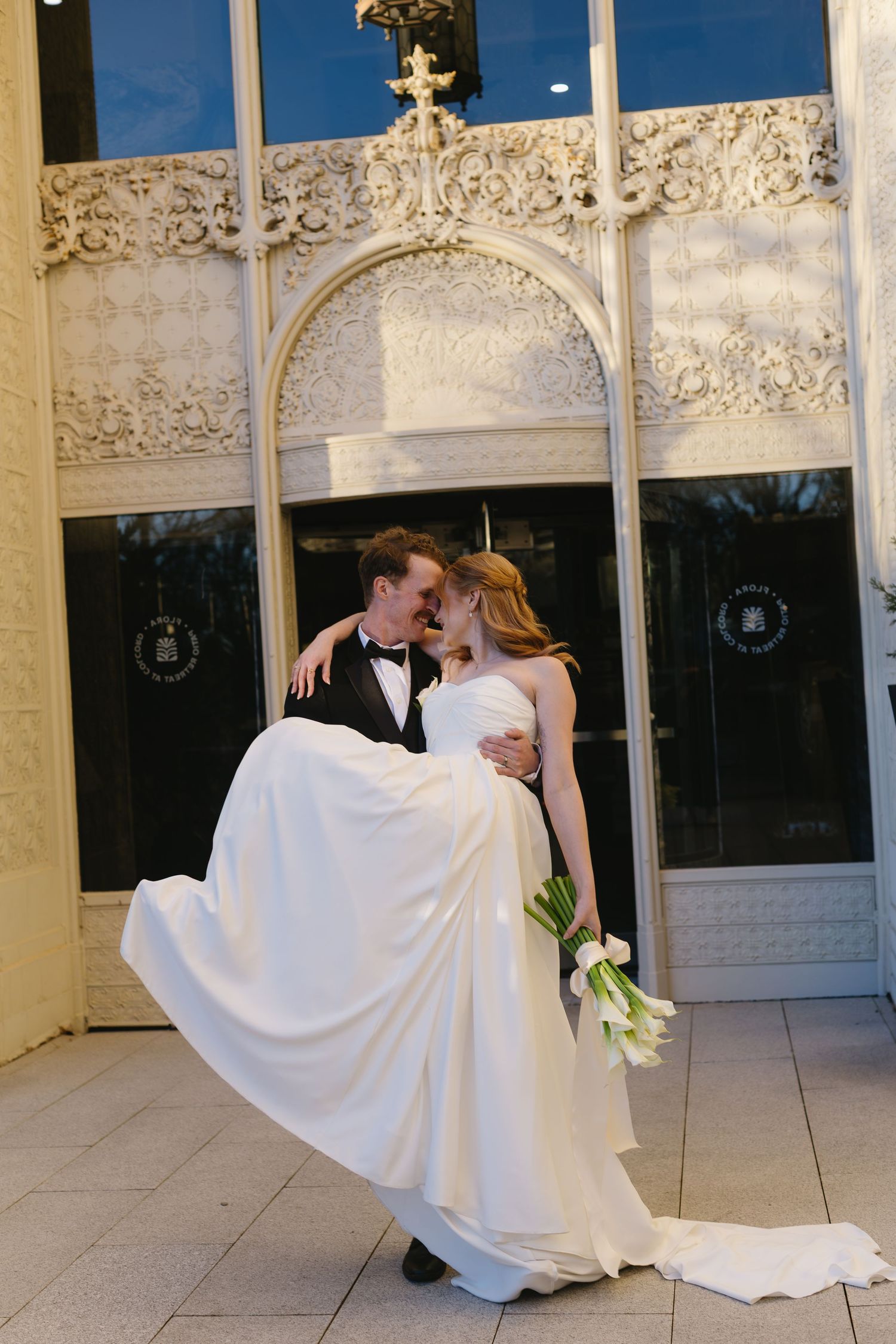 Romantic wedding moment captured under a decorative white gazebo.