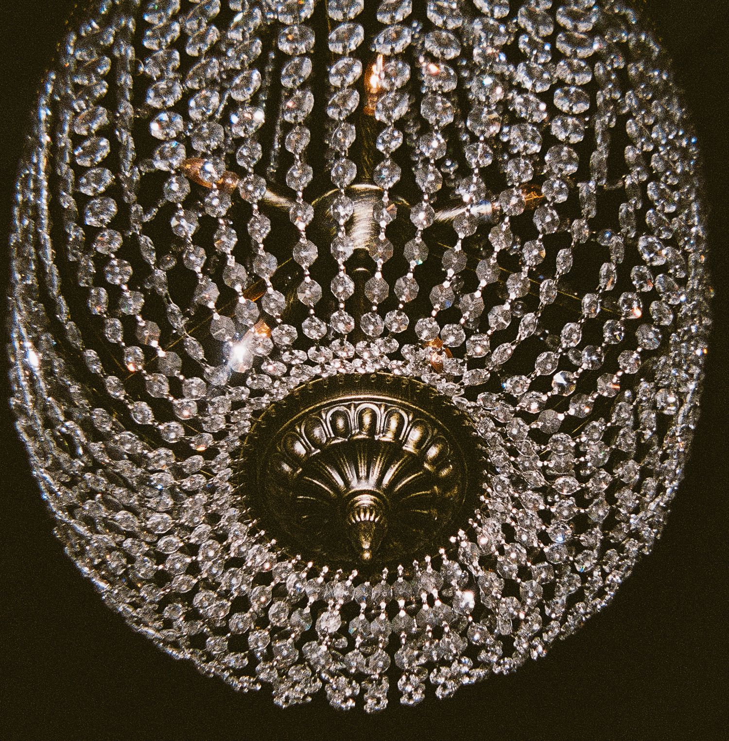 Close-up of an ornate crystal chandelier with concentric circles of hanging crystals.