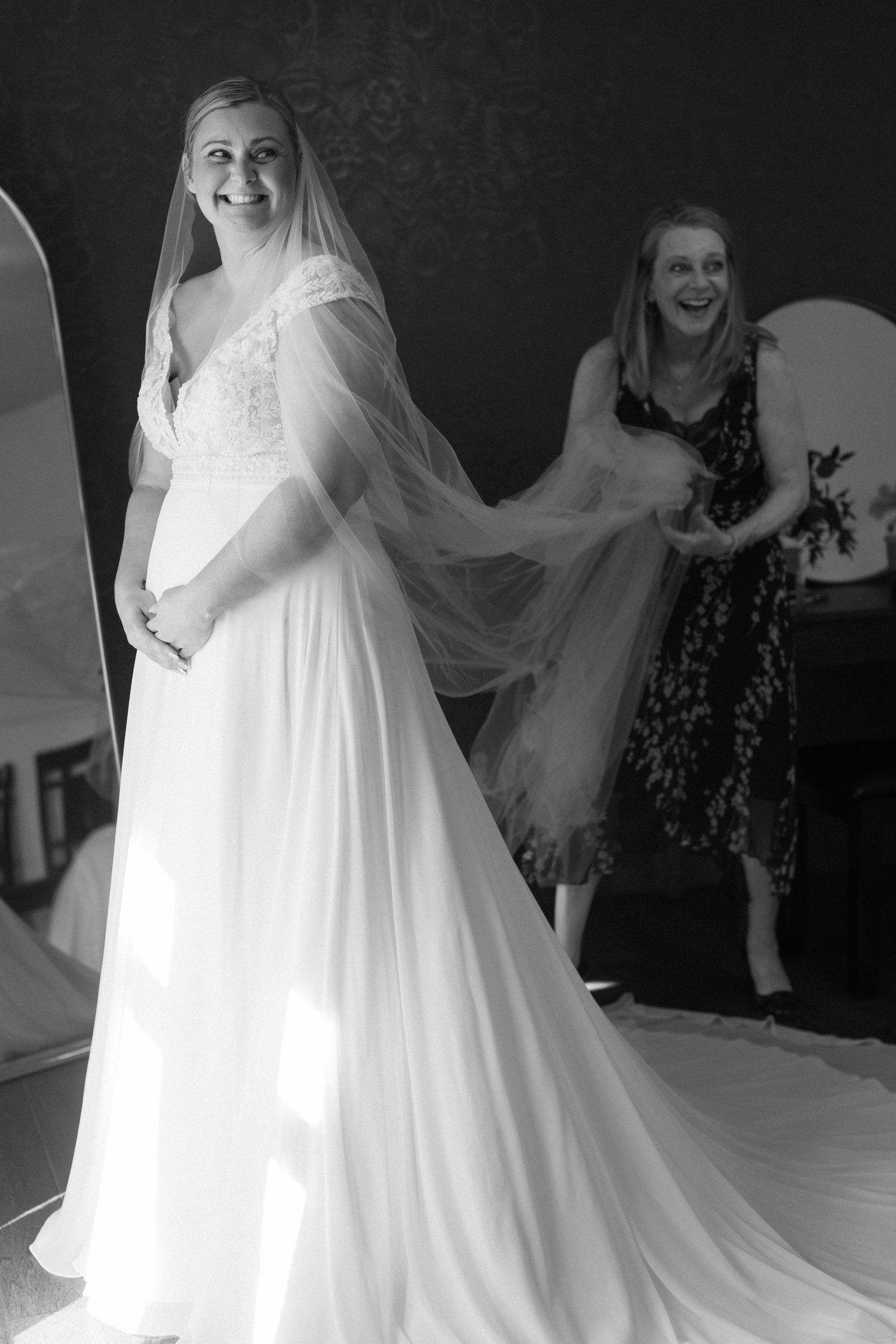 A flowing white wedding gown being displayed during a bridal fitting.