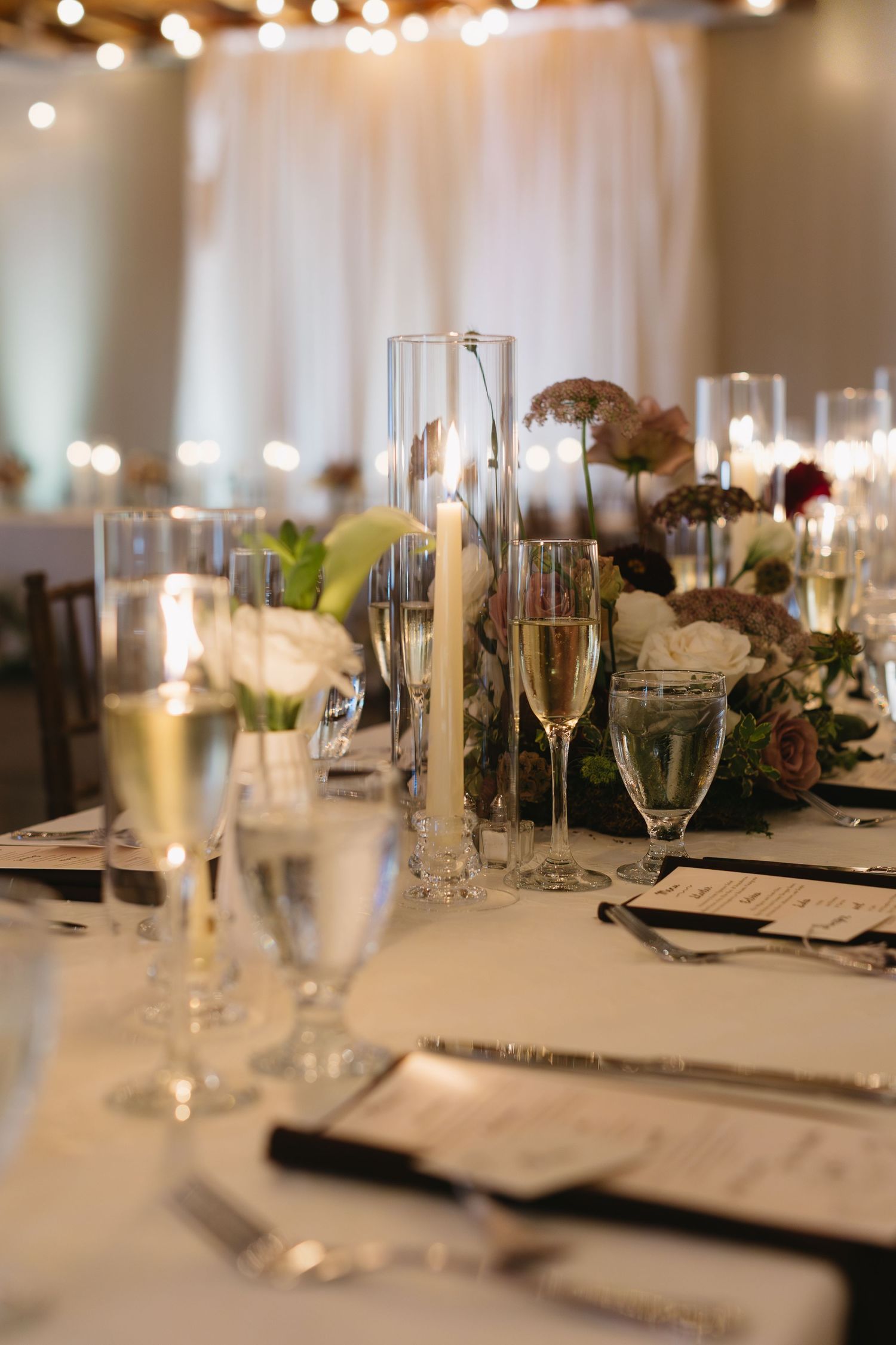 Elegant wedding reception table setting with champagne flutes and place cards.