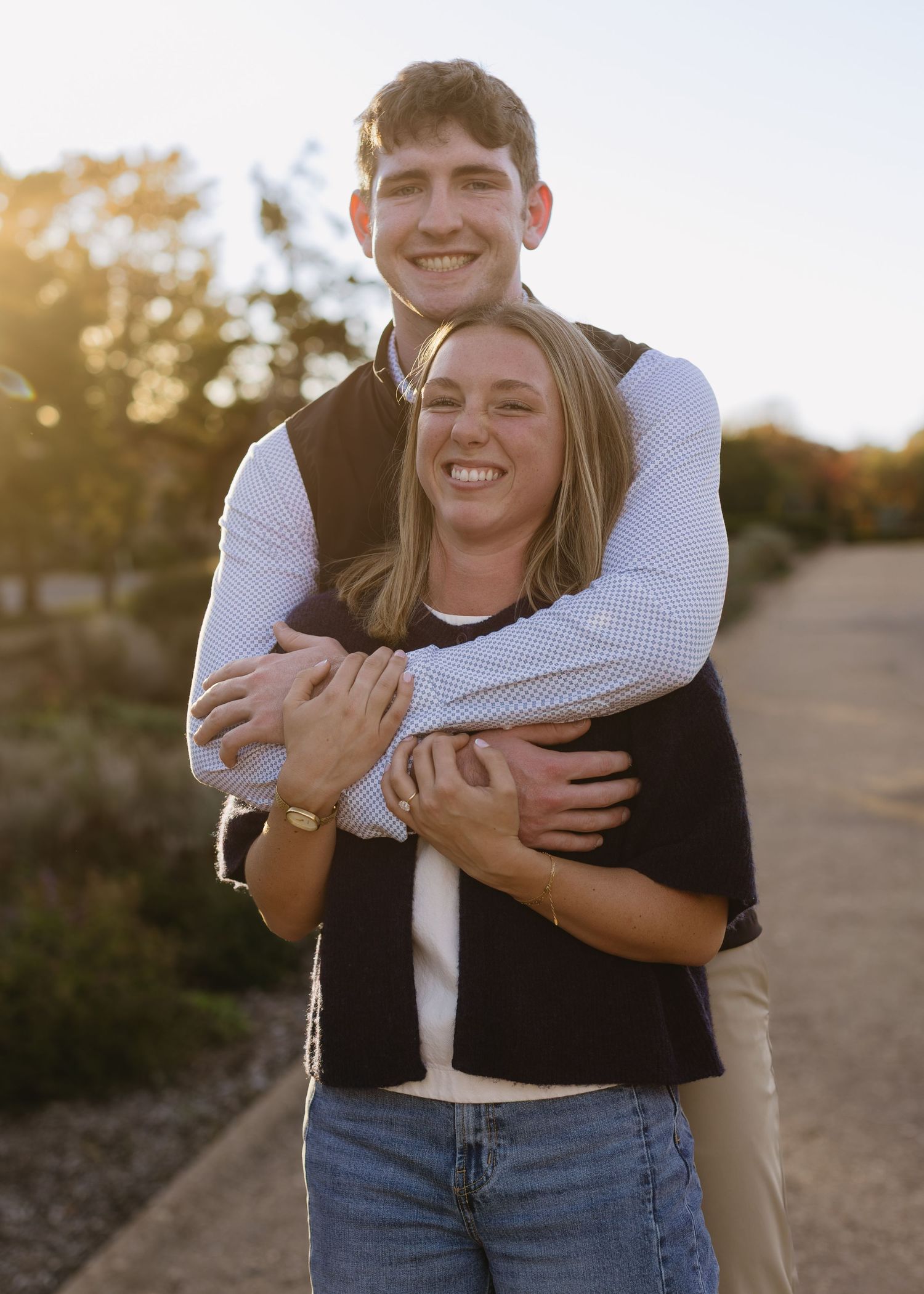 Playful embrace captured in warm sunlight on a nature path.