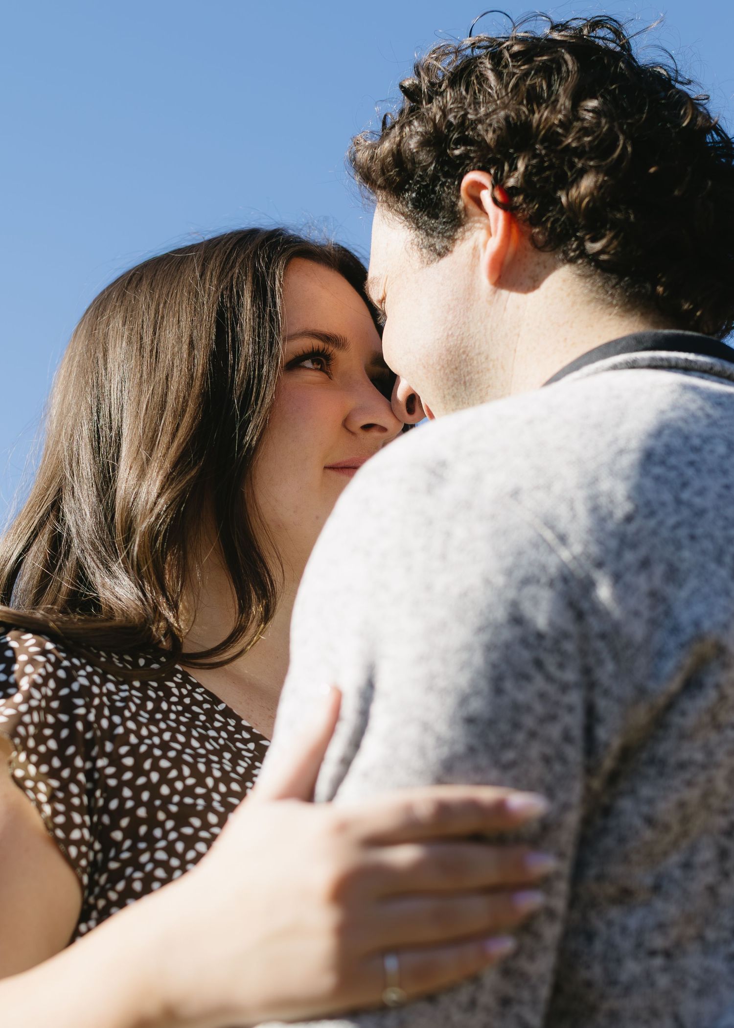 Close-up shots of a couple in casual wear sharing intimate moments during a photoshoot.