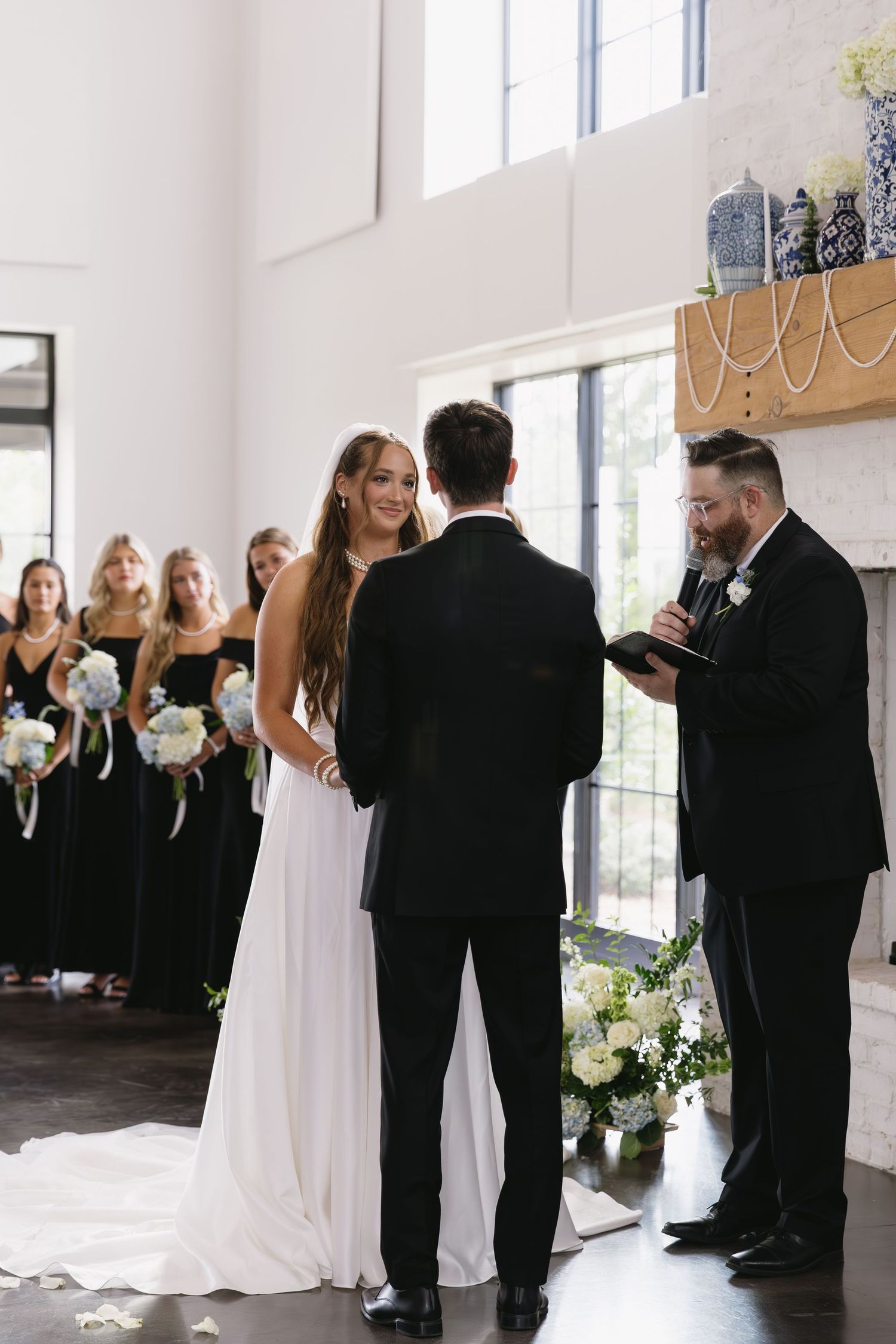 Wedding party in black and white attire arranges for formal photos.