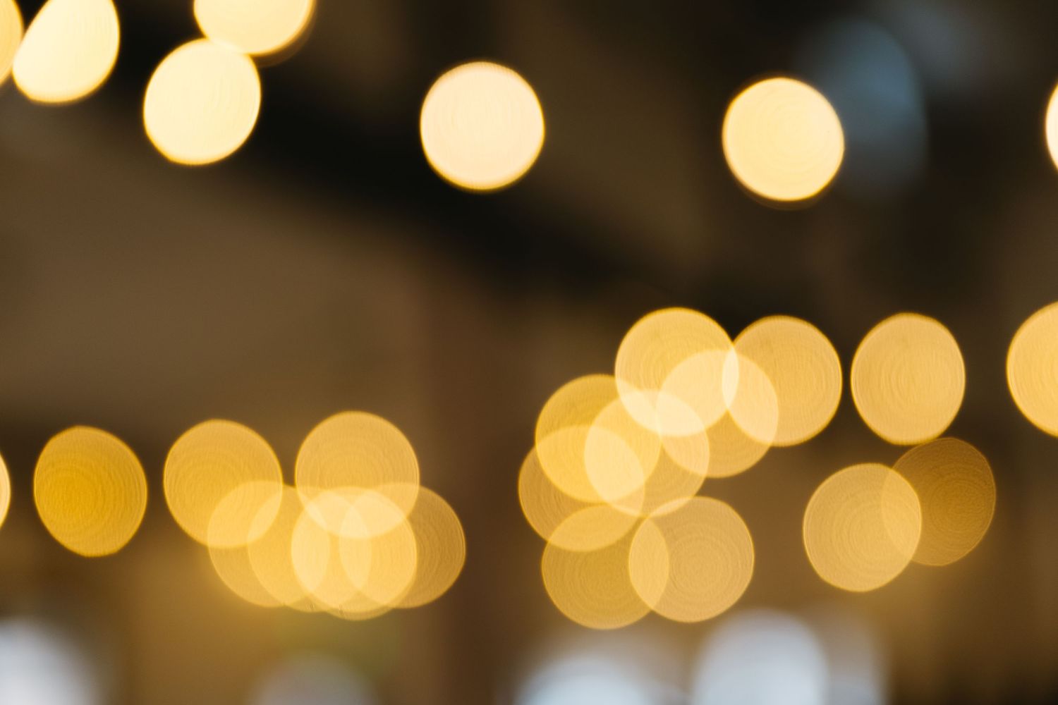 Warm bokeh lights creating a magical golden glow in a dark setting.
