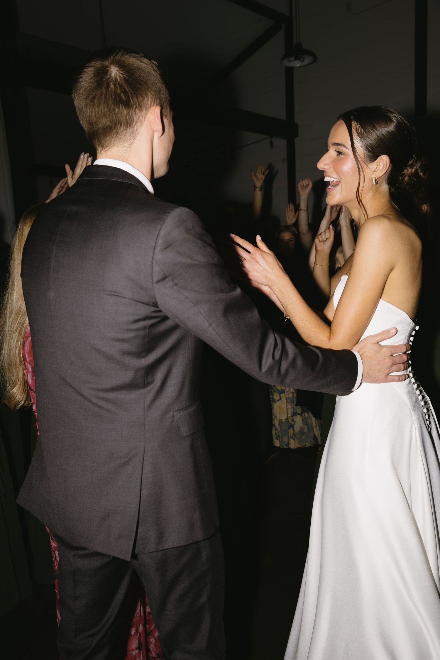 A couple in wedding attire share an intimate dance moment at their reception.