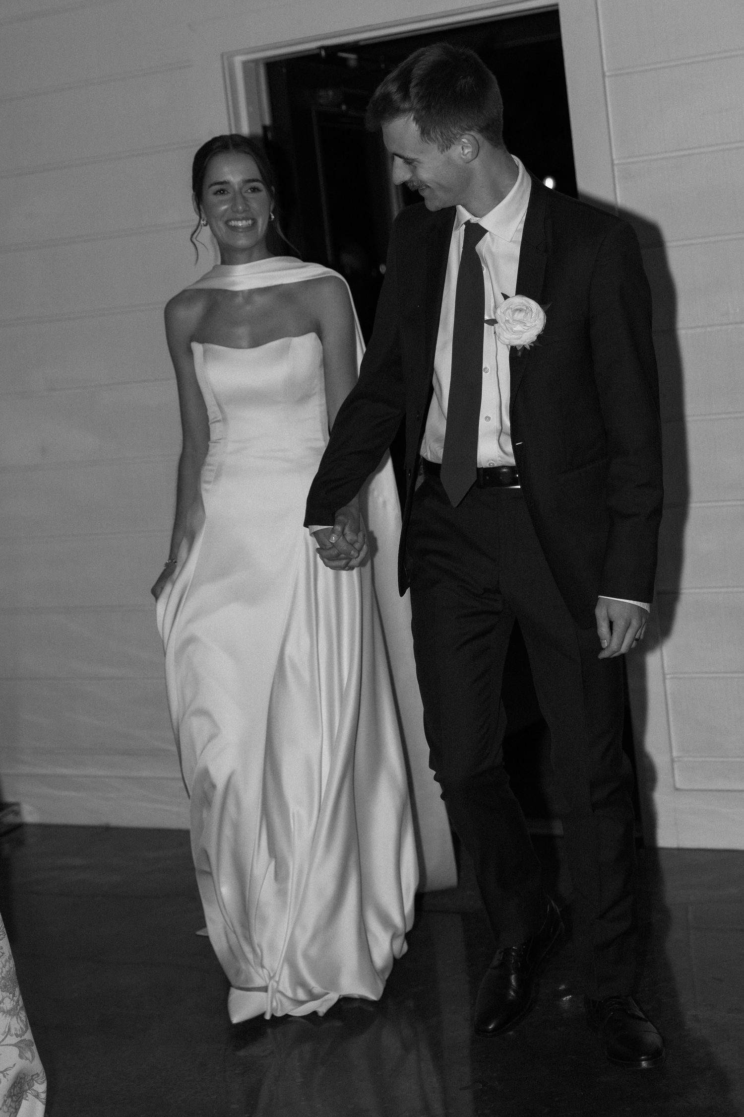 Black and white photos of newlyweds walking together in elegant wedding attire.
