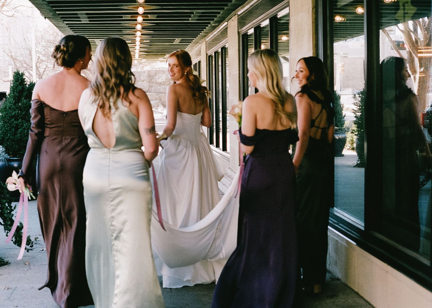 Wedding guests in formal attire gathered outside a venue entrance.
