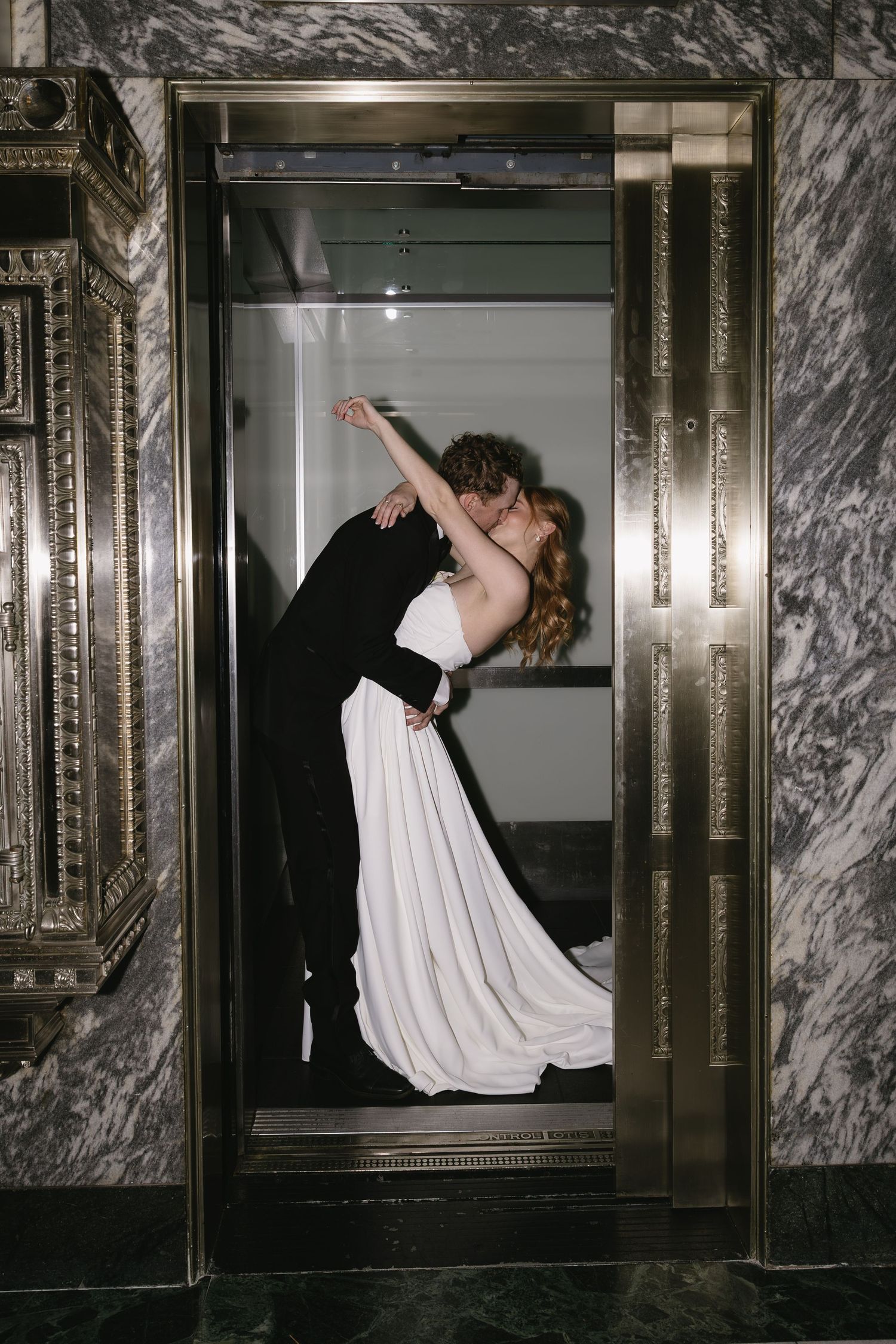 Artistic wedding photos in marble elevator showing romantic dance movements.