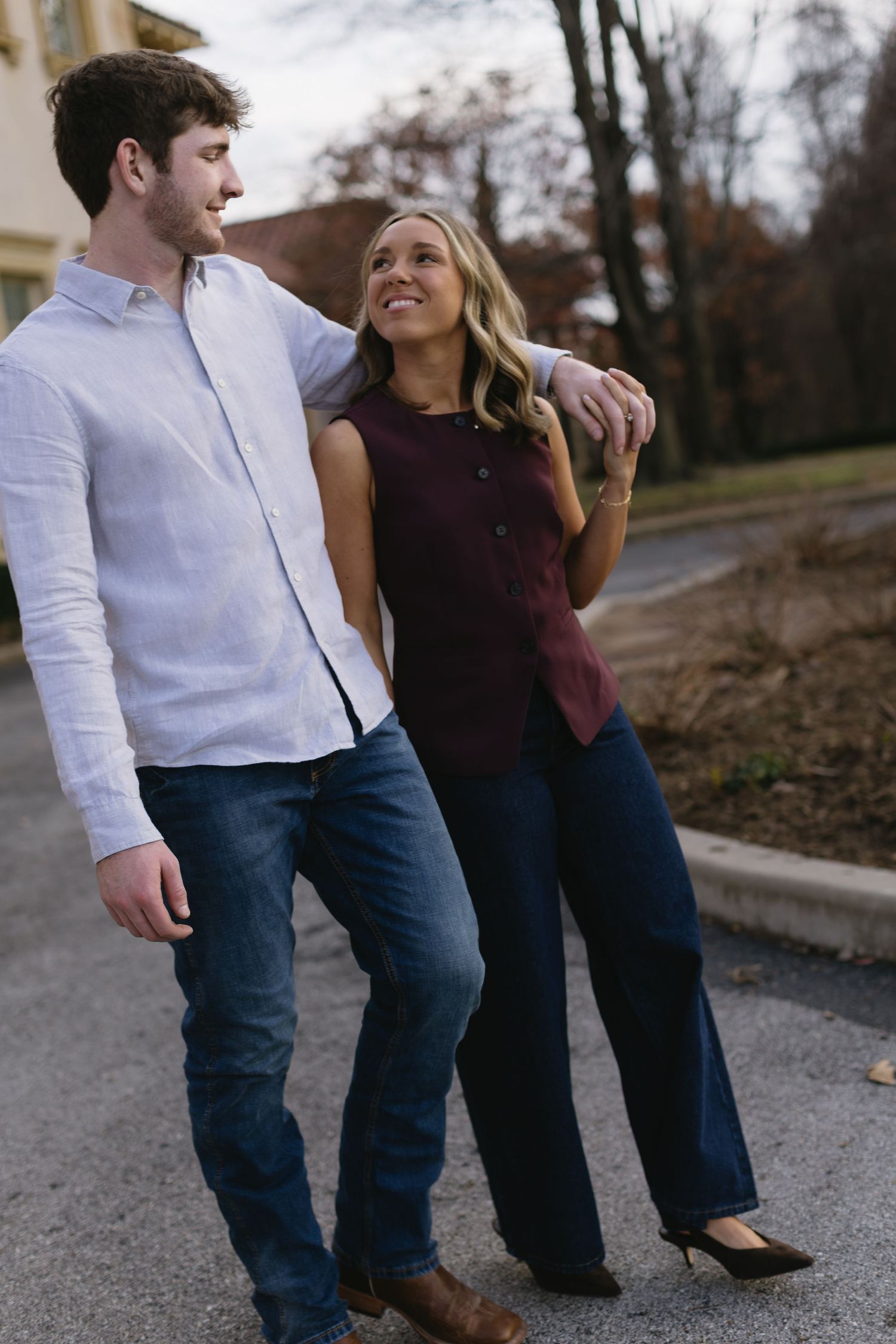 Couple in casual attire sharing a playful moment while walking outdoors.