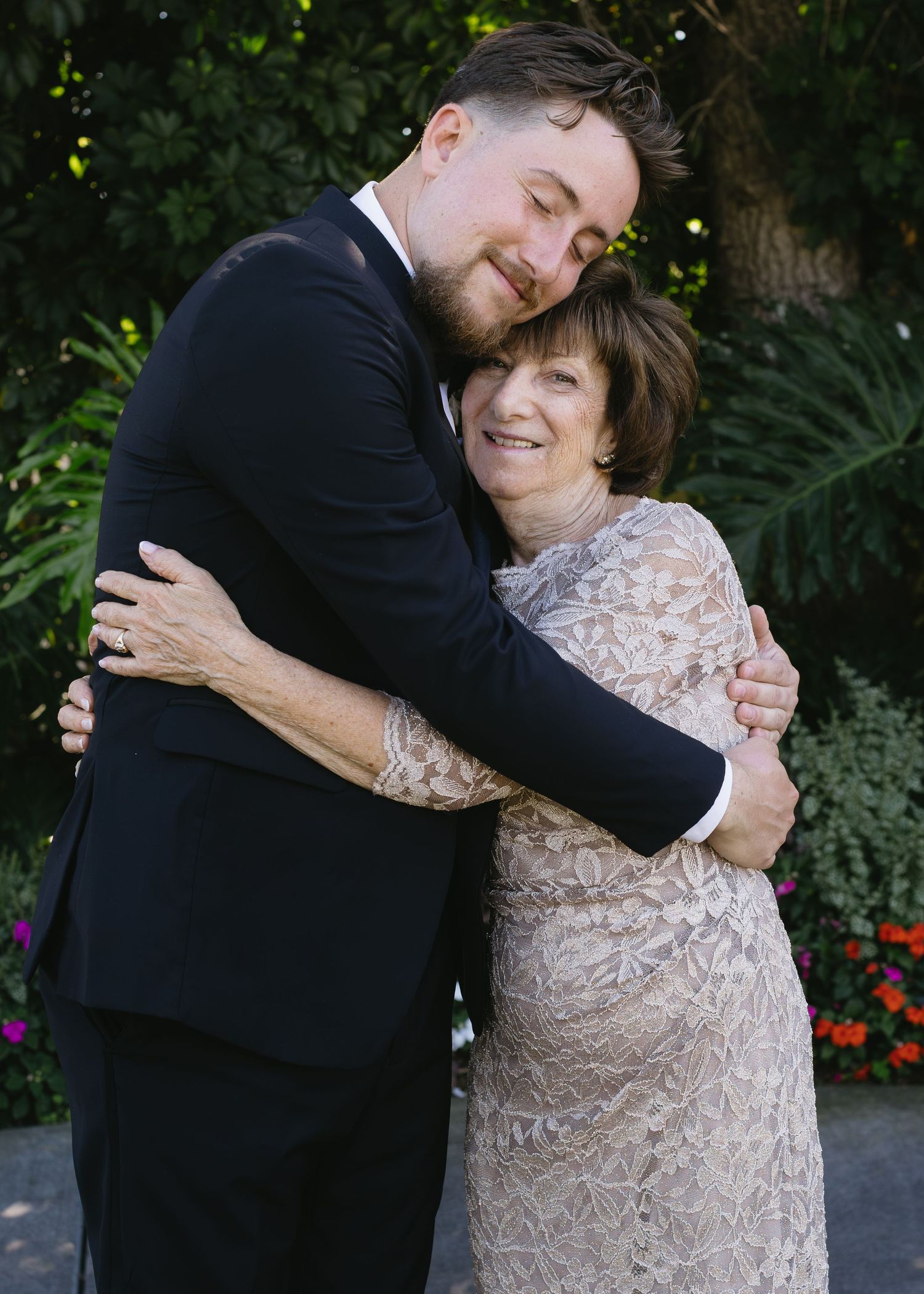 Emotional embrace between two people at wedding celebration.
