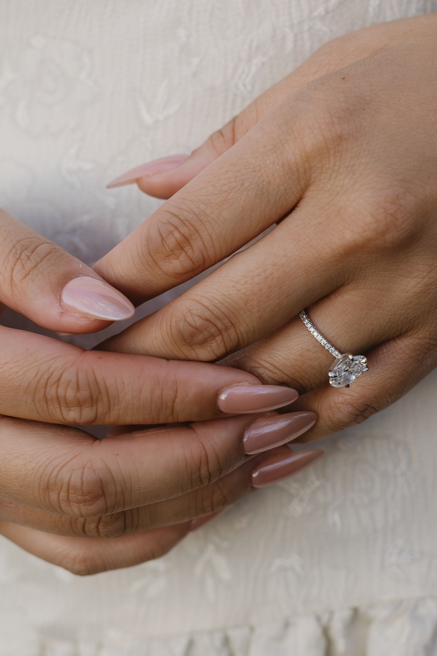 Close-up shots of hands displaying an elegant diamond engagement ring.