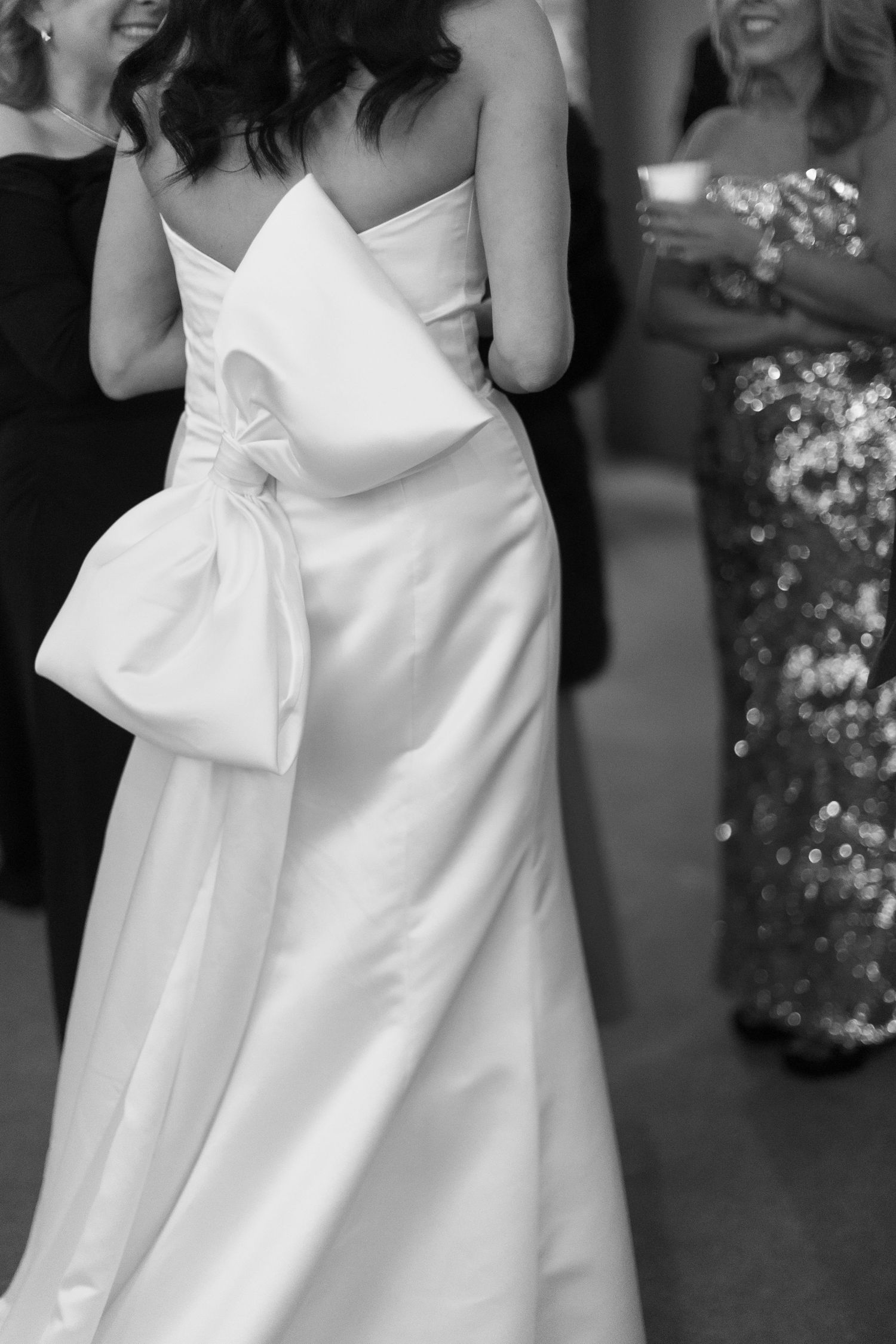Elegant white wedding dress with a large bow detail shown in a series of close-up shots.