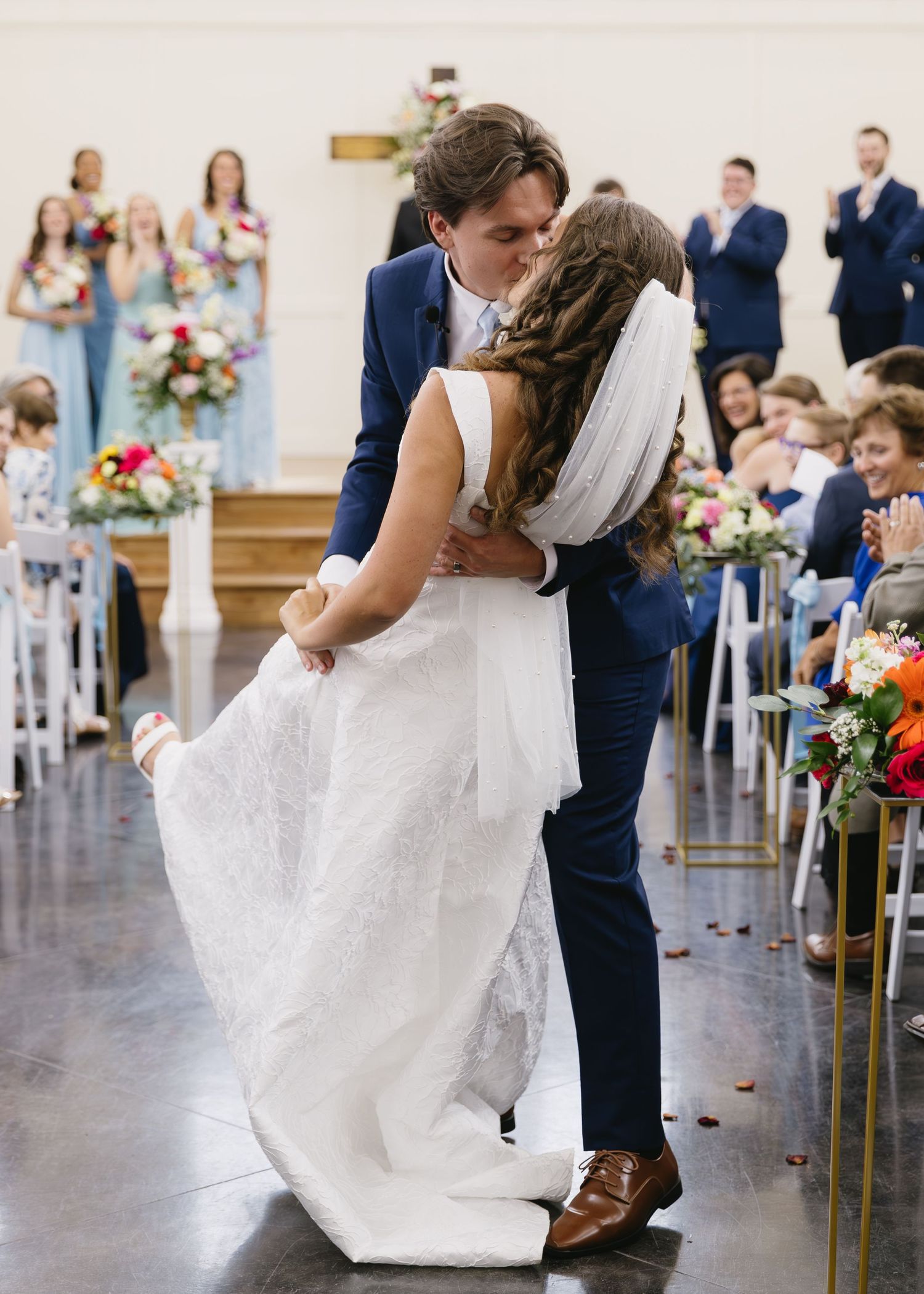 Wedding couple sharing romantic dance moves during their first dance in a bright reception hall.