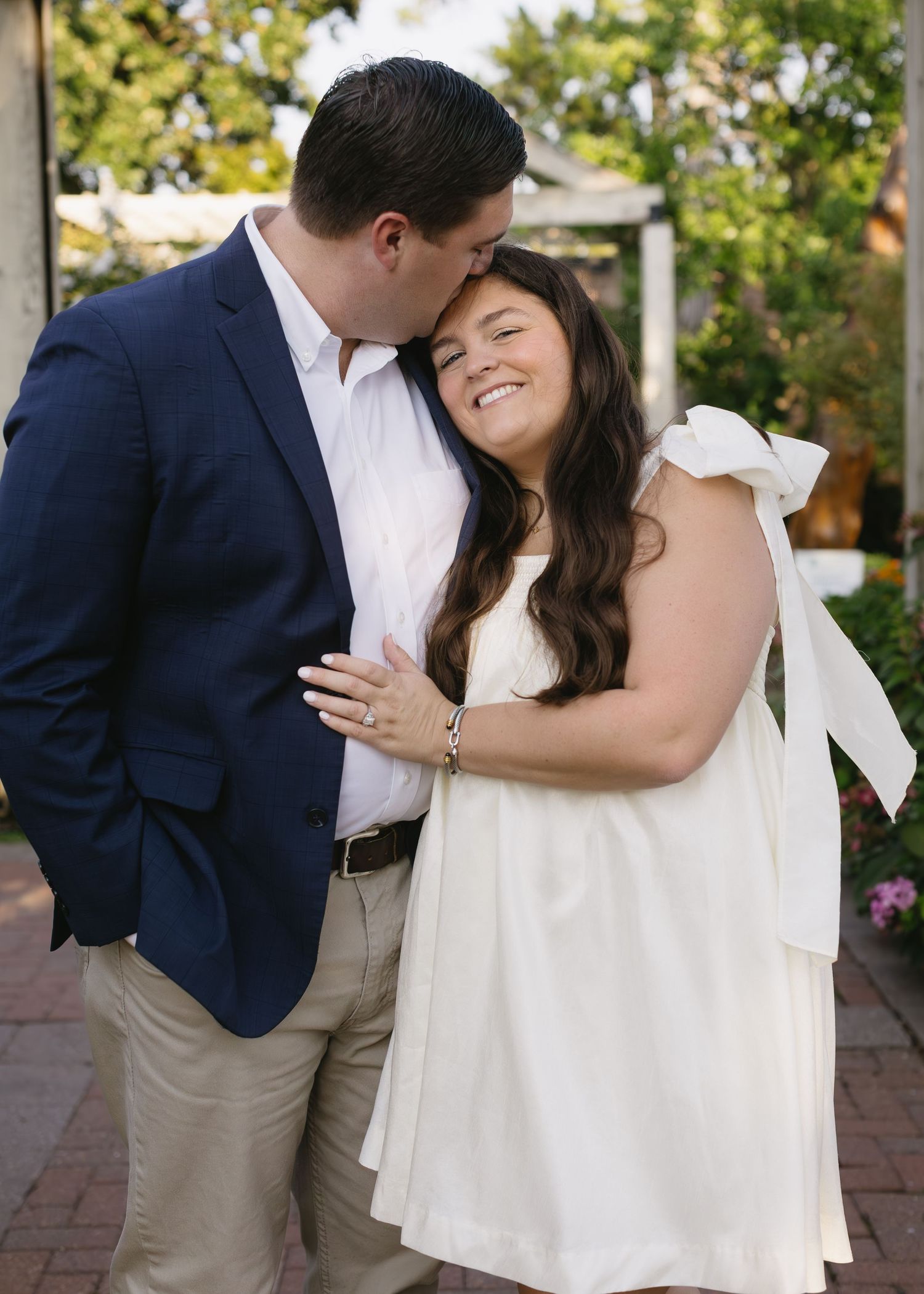 A tender moment between a couple as they embrace near flowering plants.