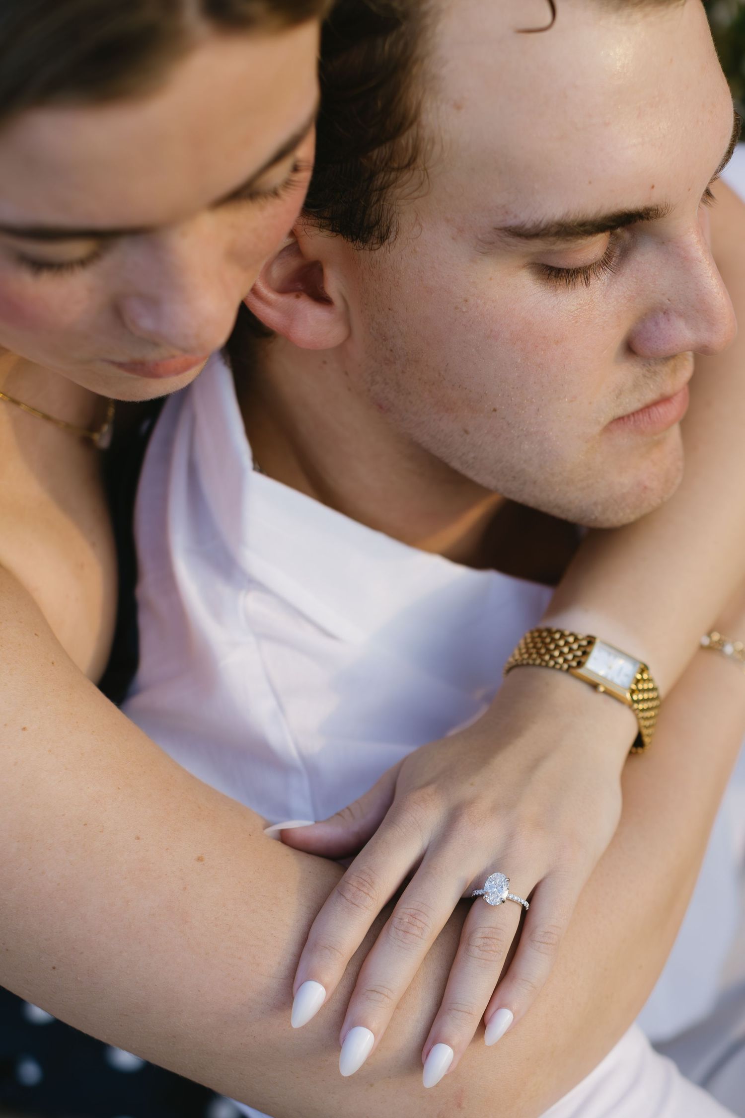 Close-up detail of hands and jewelry during an intimate embrace.