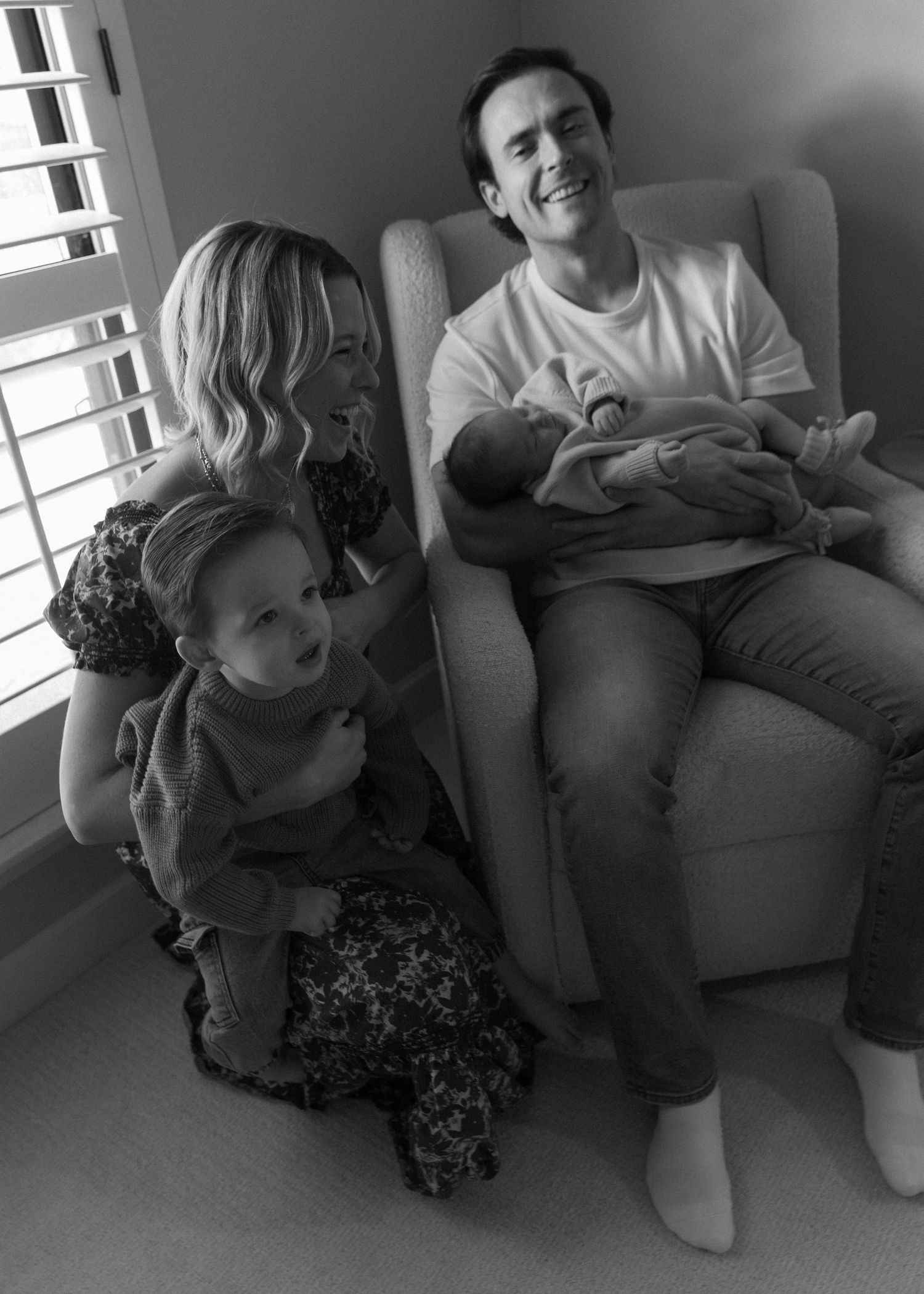 A heartwarming family moment shared in a cozy armchair by a window.