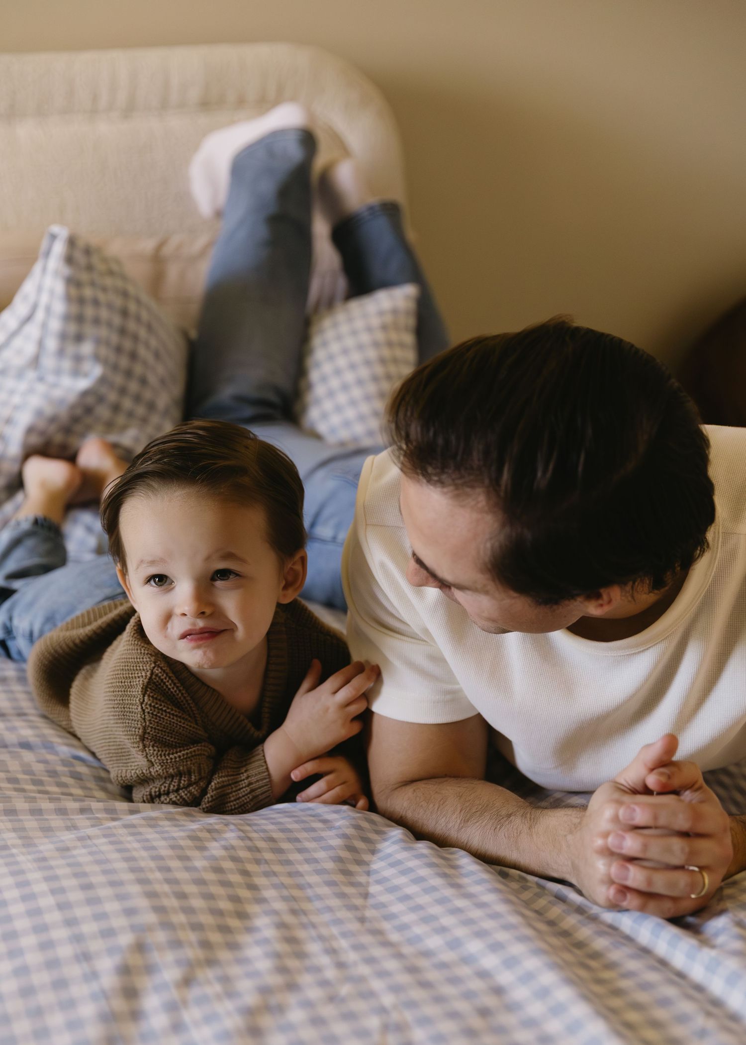 Intimate family moments captured in black and white on checkered bedding.