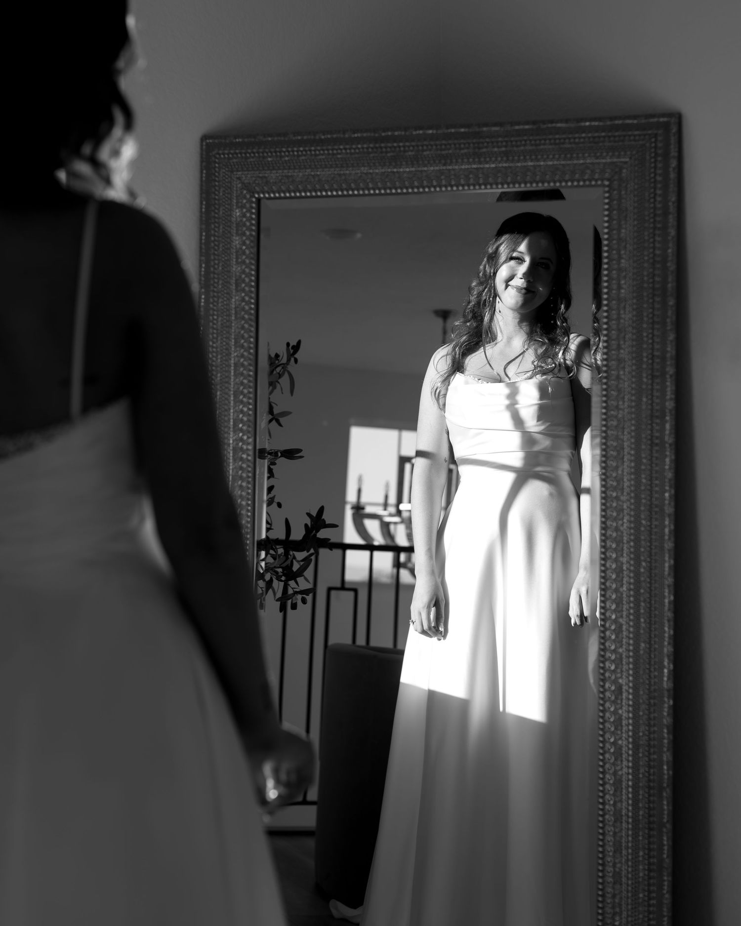 A dramatic black and white series showing a person in white clothing reflected in a mirror with natural light streaming in.