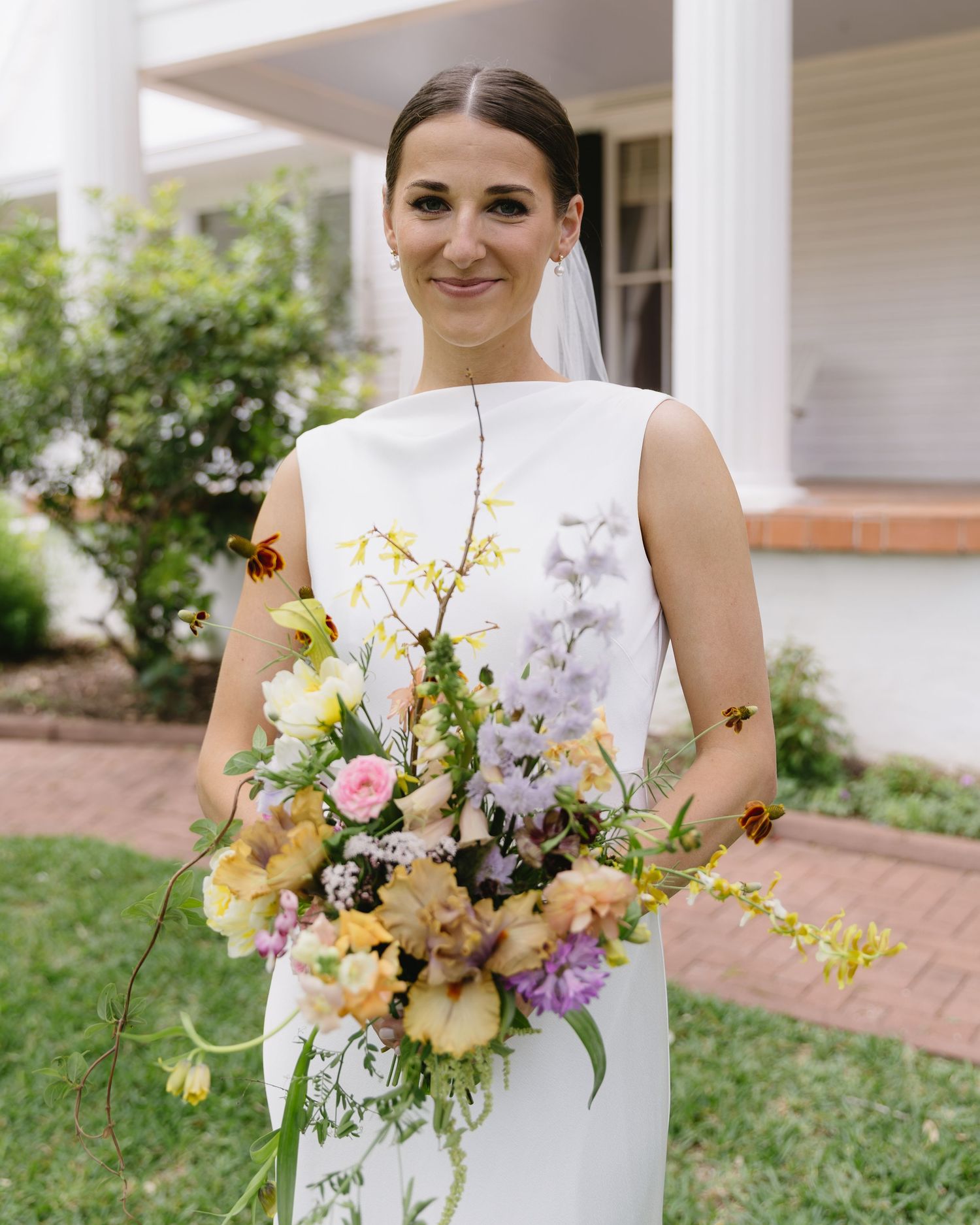 Elegant springtime bridal bouquet with yellow, pink and purple wildflowers.