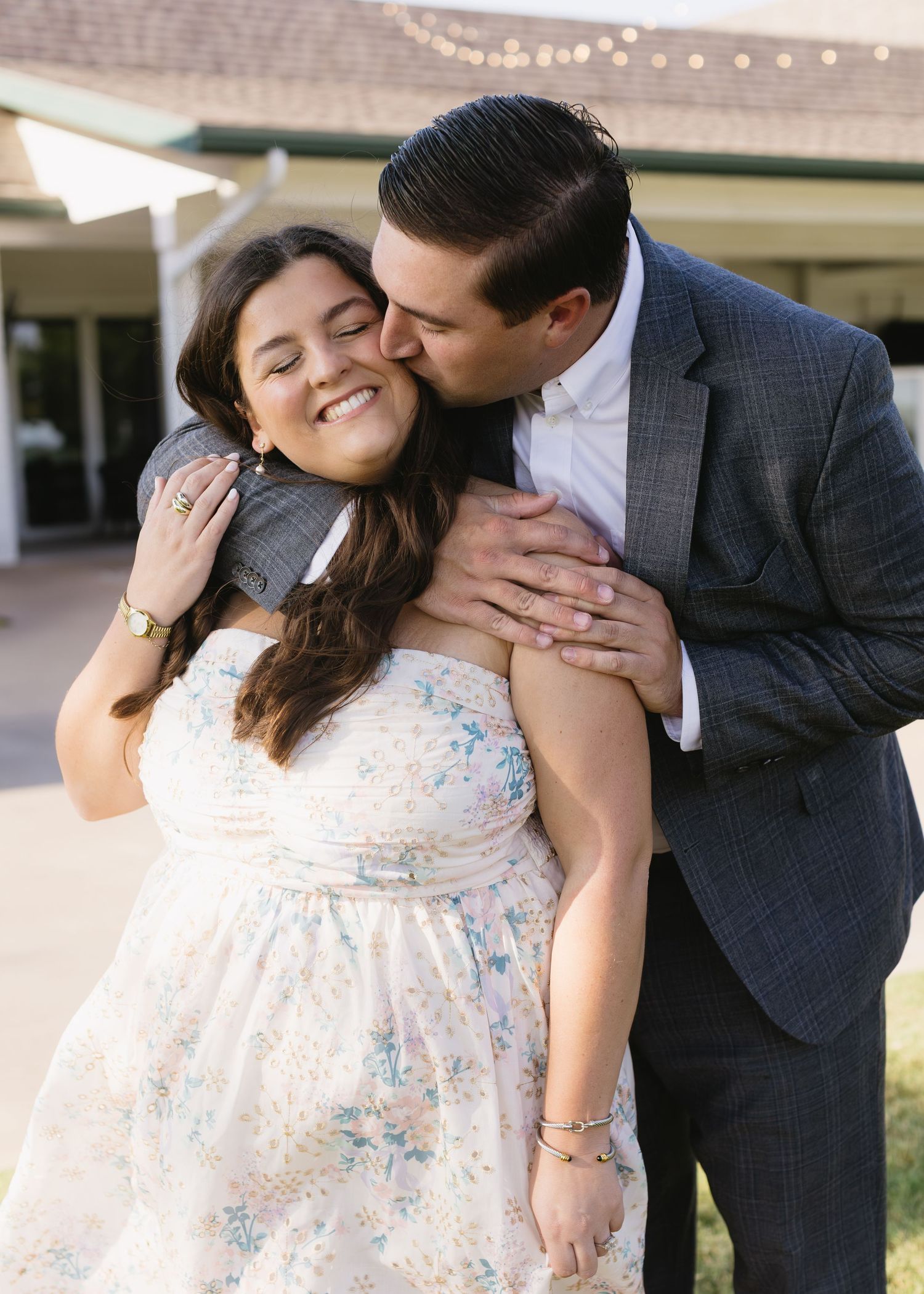 Sweet candid moments of a couple in formal wear sharing intimate gestures outdoors.