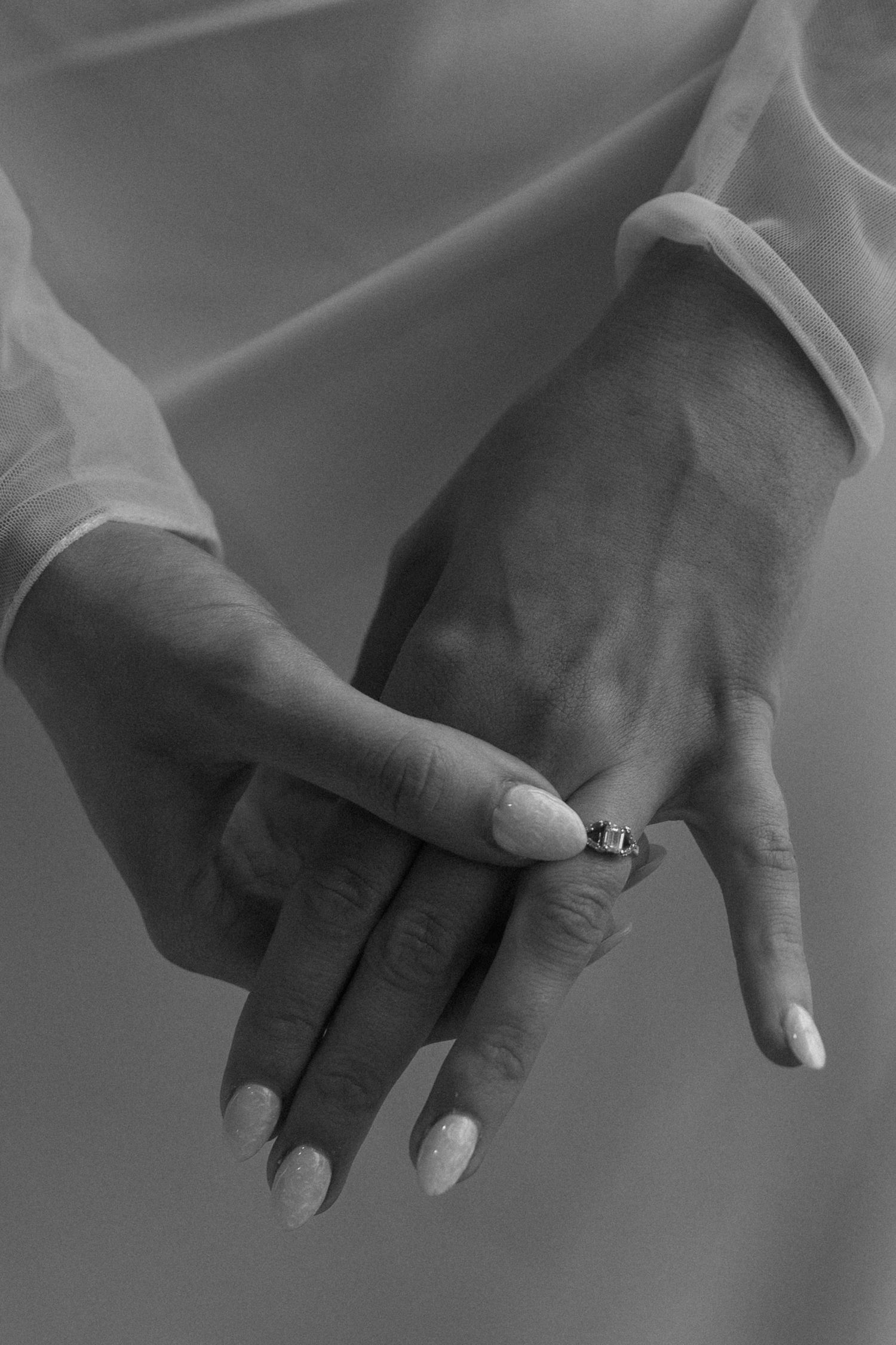 Black and white close-up images showing a series of hand gestures in sequence against a soft blurred background.