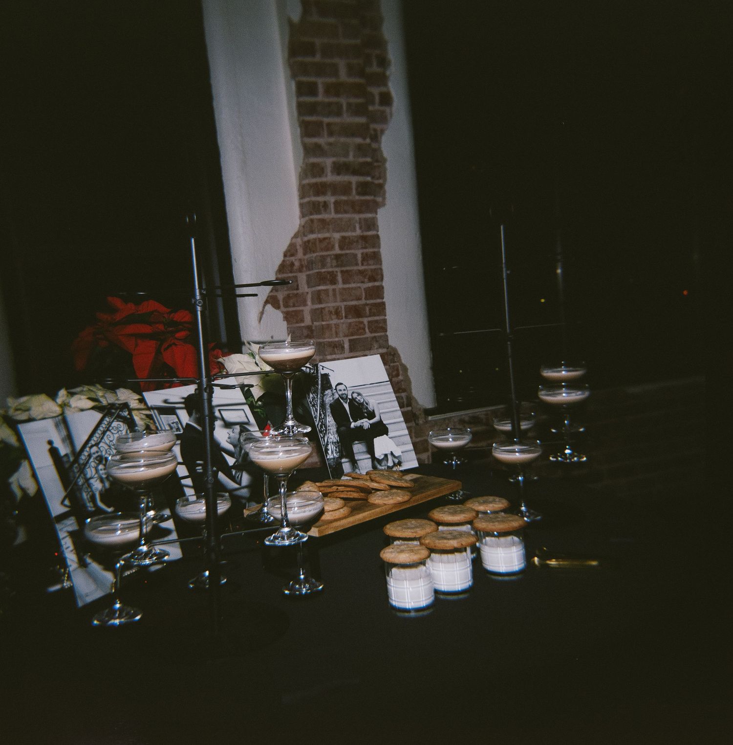 Dark room with kitchen items and jars arranged on a counter against a brick wall.