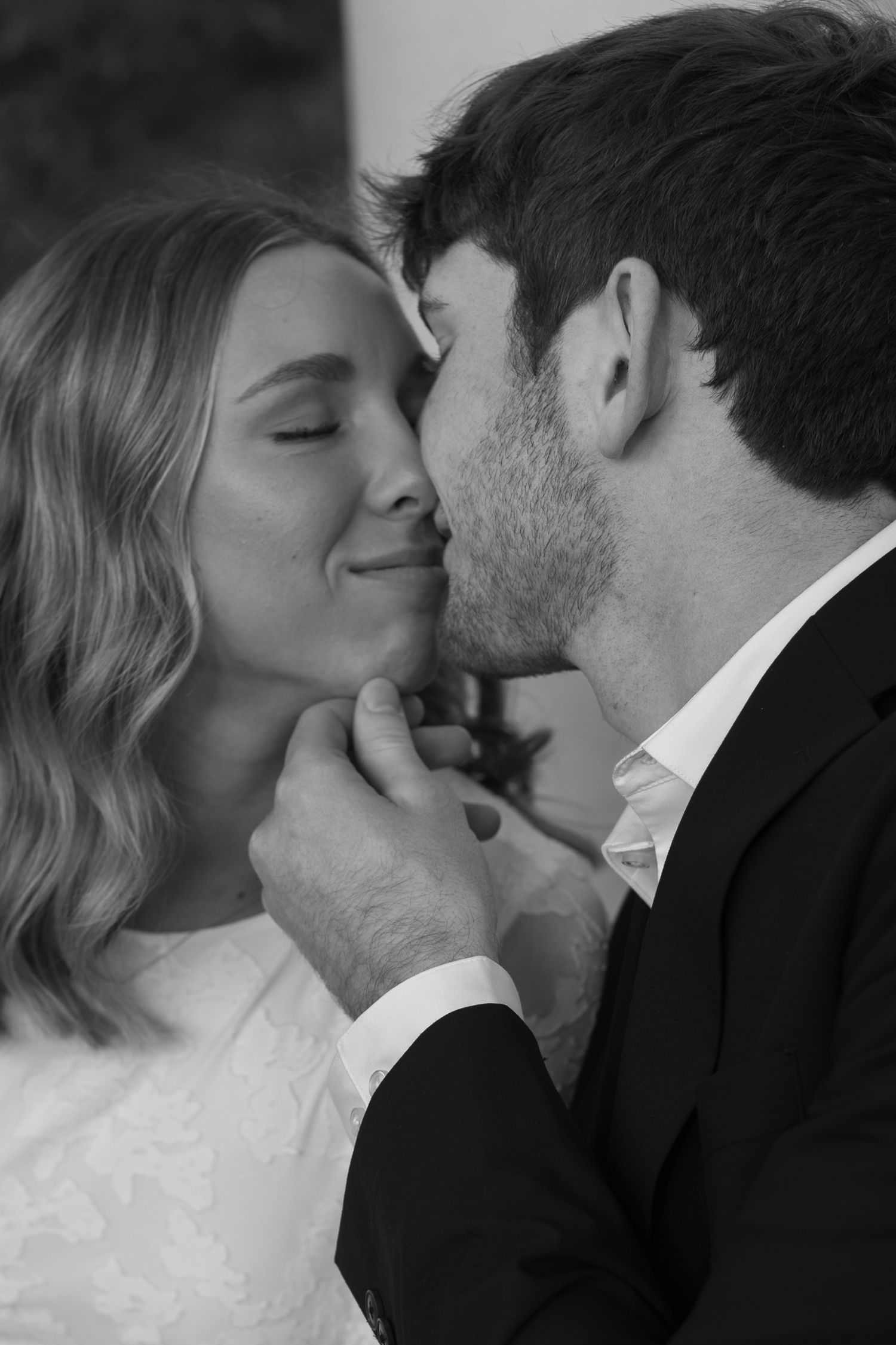 A black and white intimate portrait of a couple sharing a tender moment together.