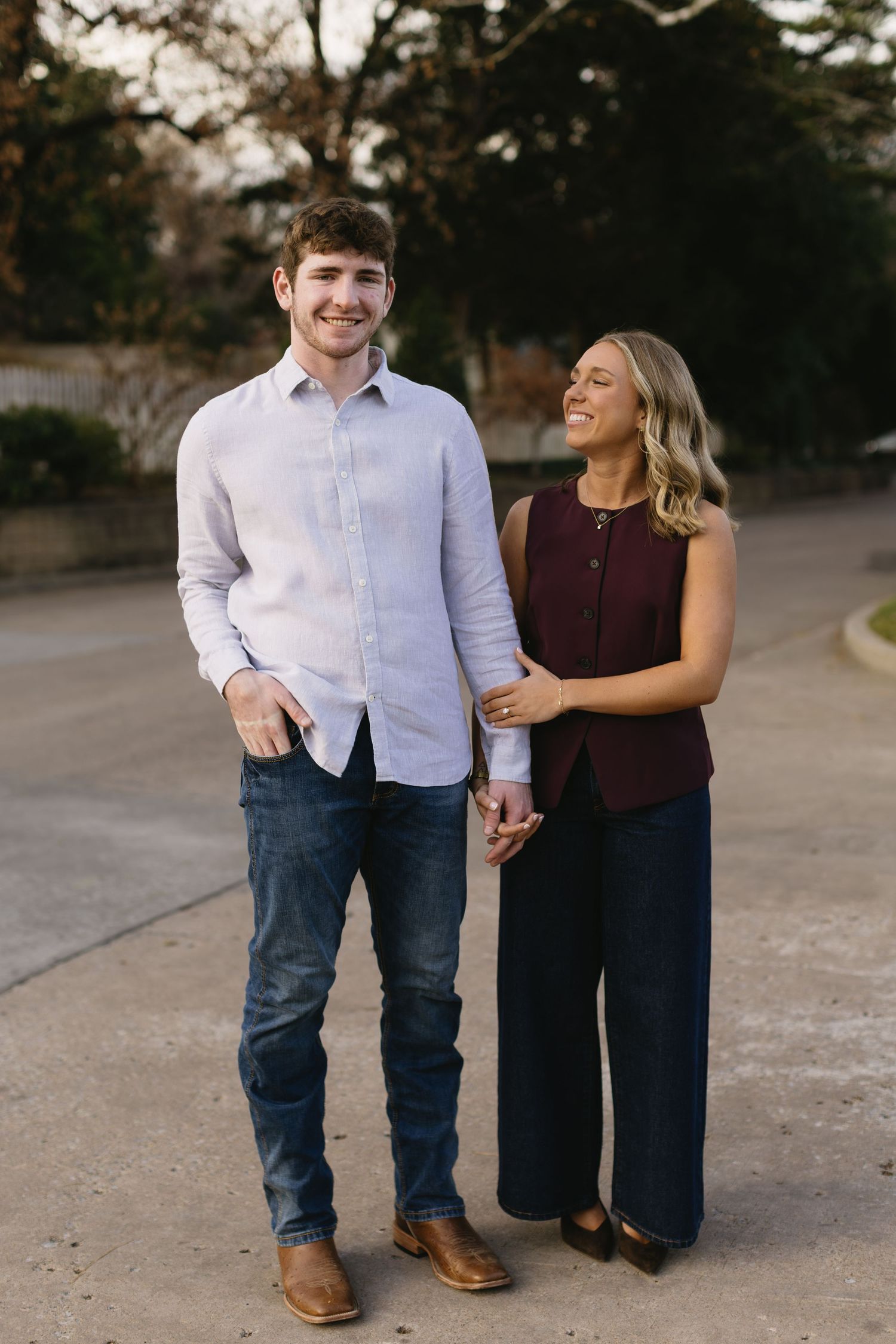 A couple shares a joyful moment while walking outdoors in casual attire.