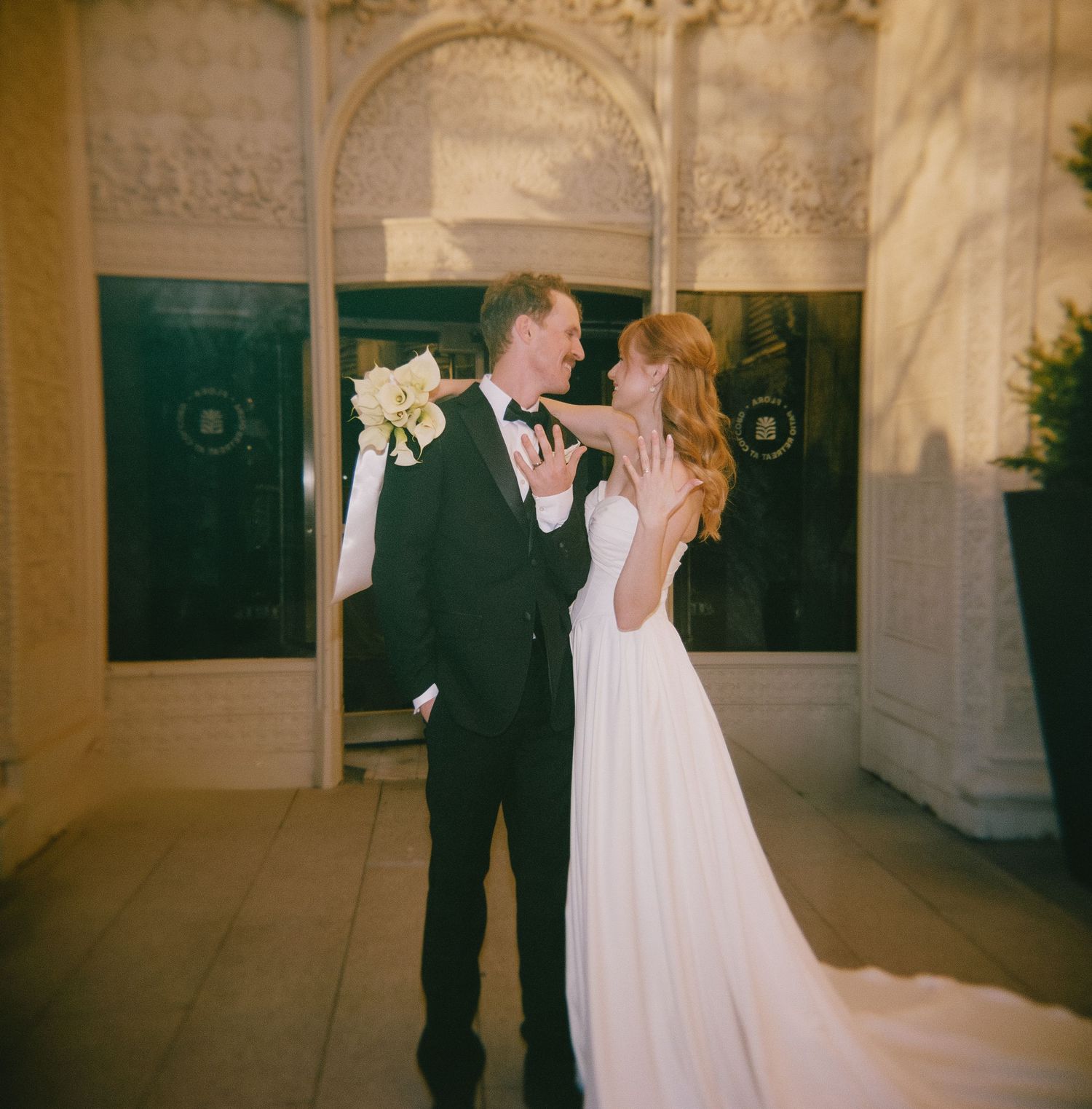 A romantic wedding moment captured in a grand architectural setting with ornate details.