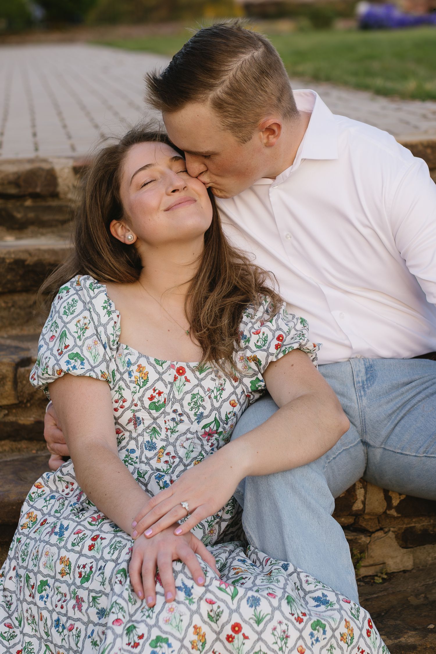 Intimate couples photography session featuring floral dress and casual attire on stone steps.