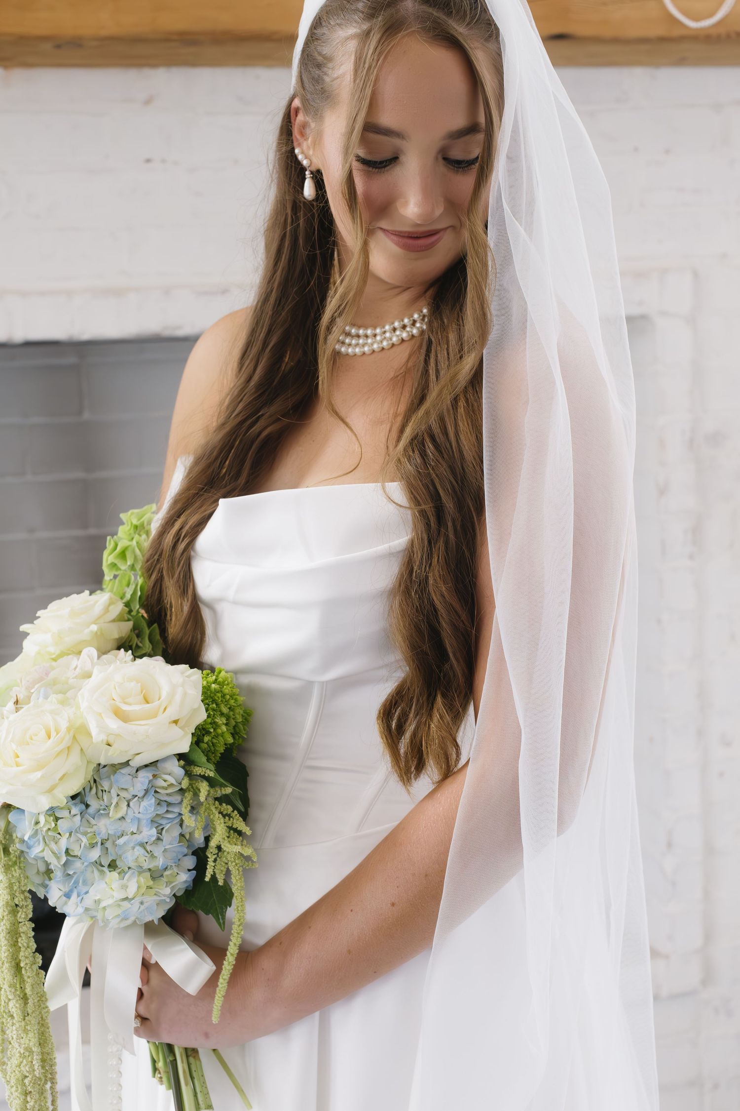 Classic white wedding dress with elegant bouquet featuring hydrangeas and roses.