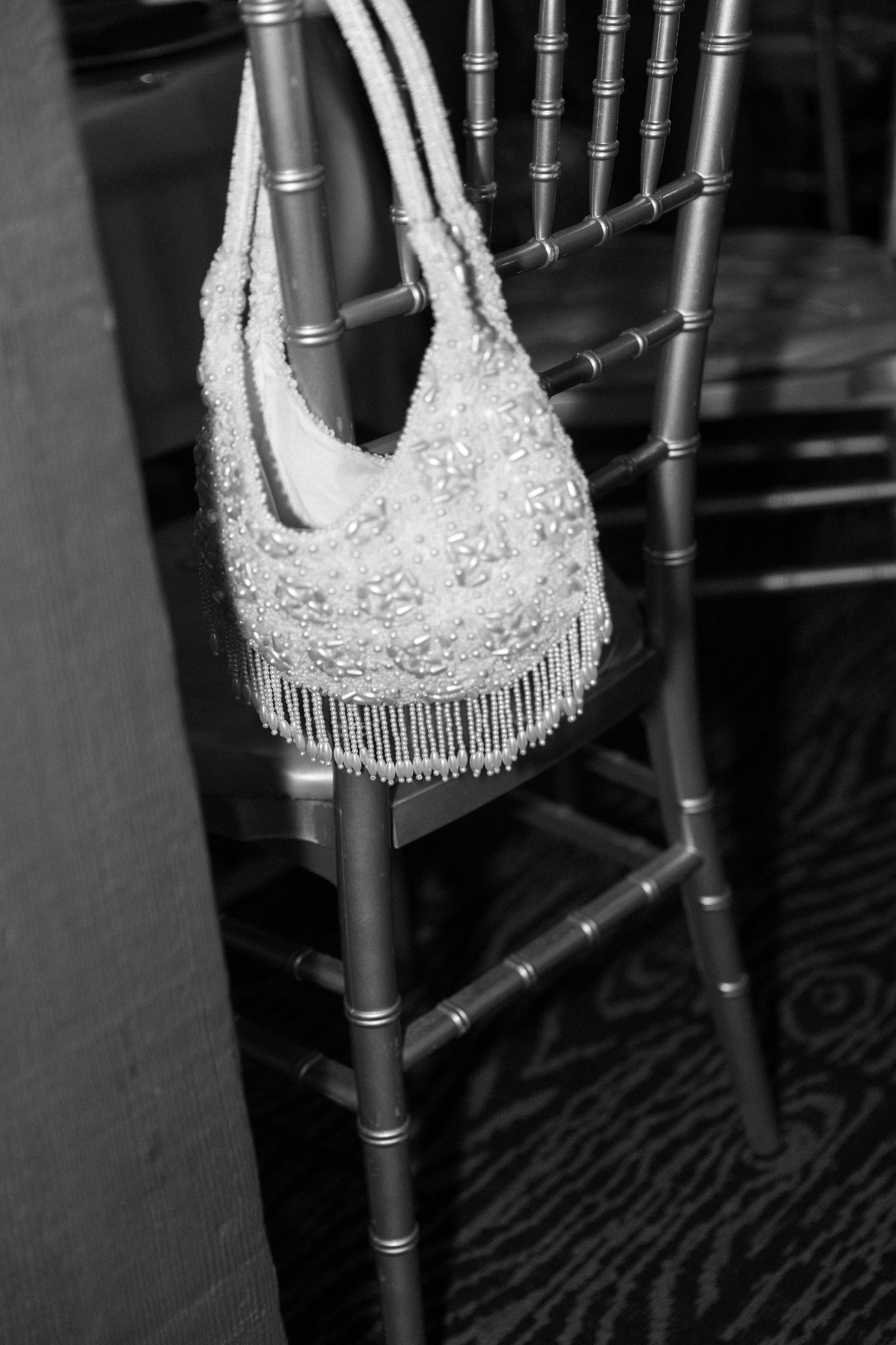 Silver chiavari chairs with ornate white lace sashes in an elegant reception setting.