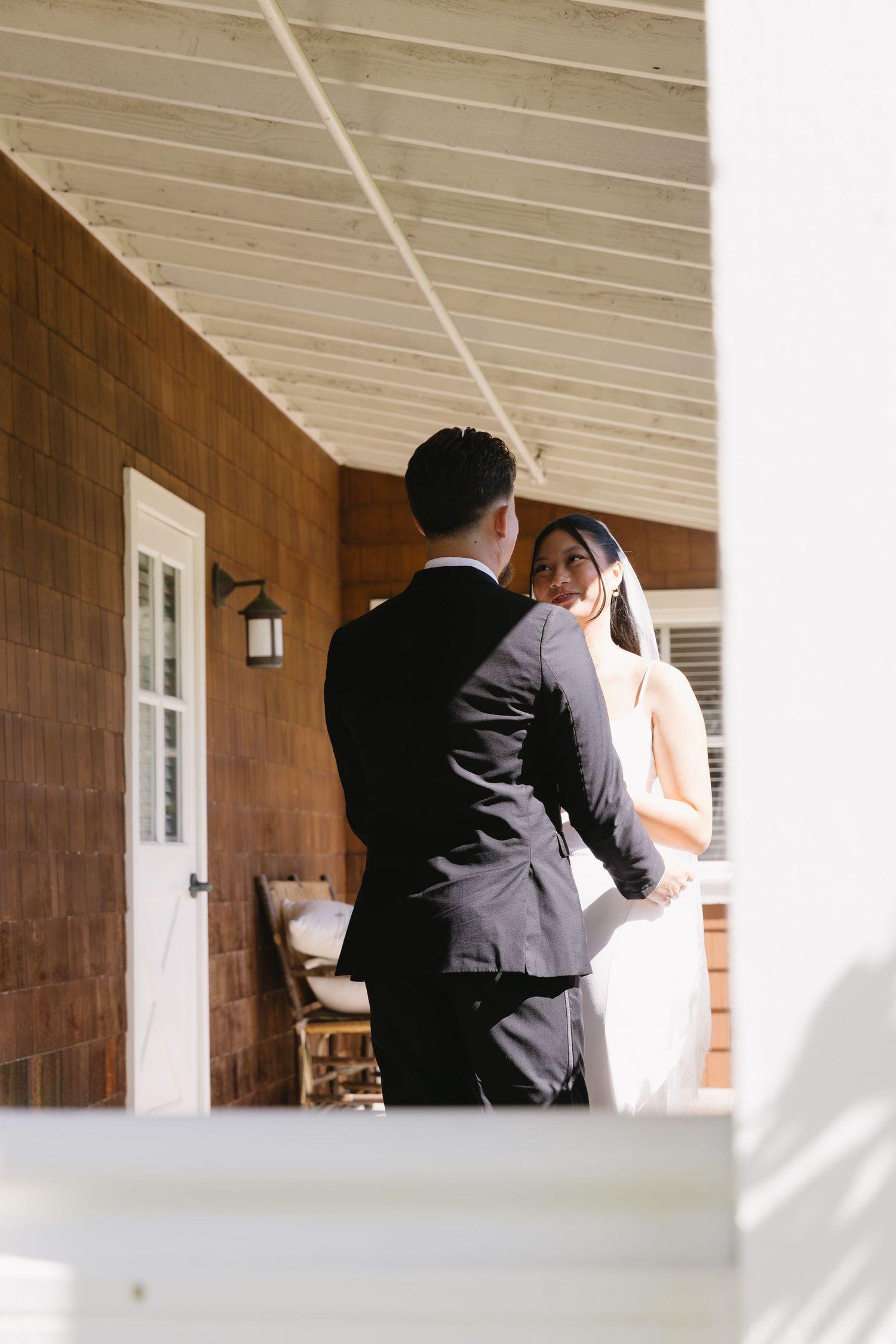 A series of black and white photos showing a couple embracing on a covered porch.