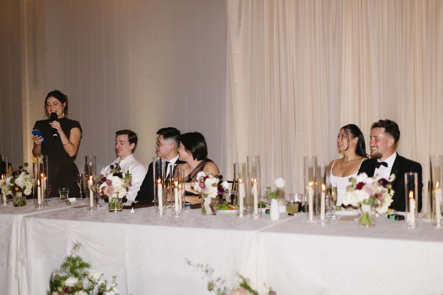 Wedding reception banquet table with elegant white decor and floral arrangements.